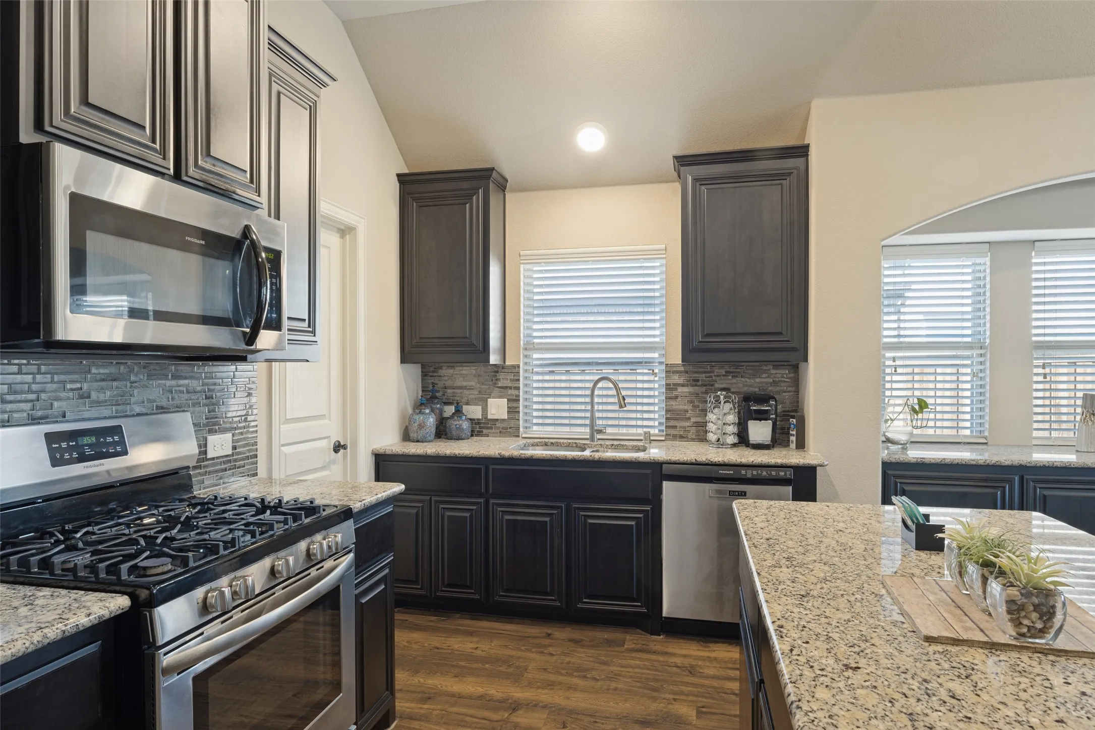 Functional galley kitchen with stainless appliances, dual sink and walk-in pantry.