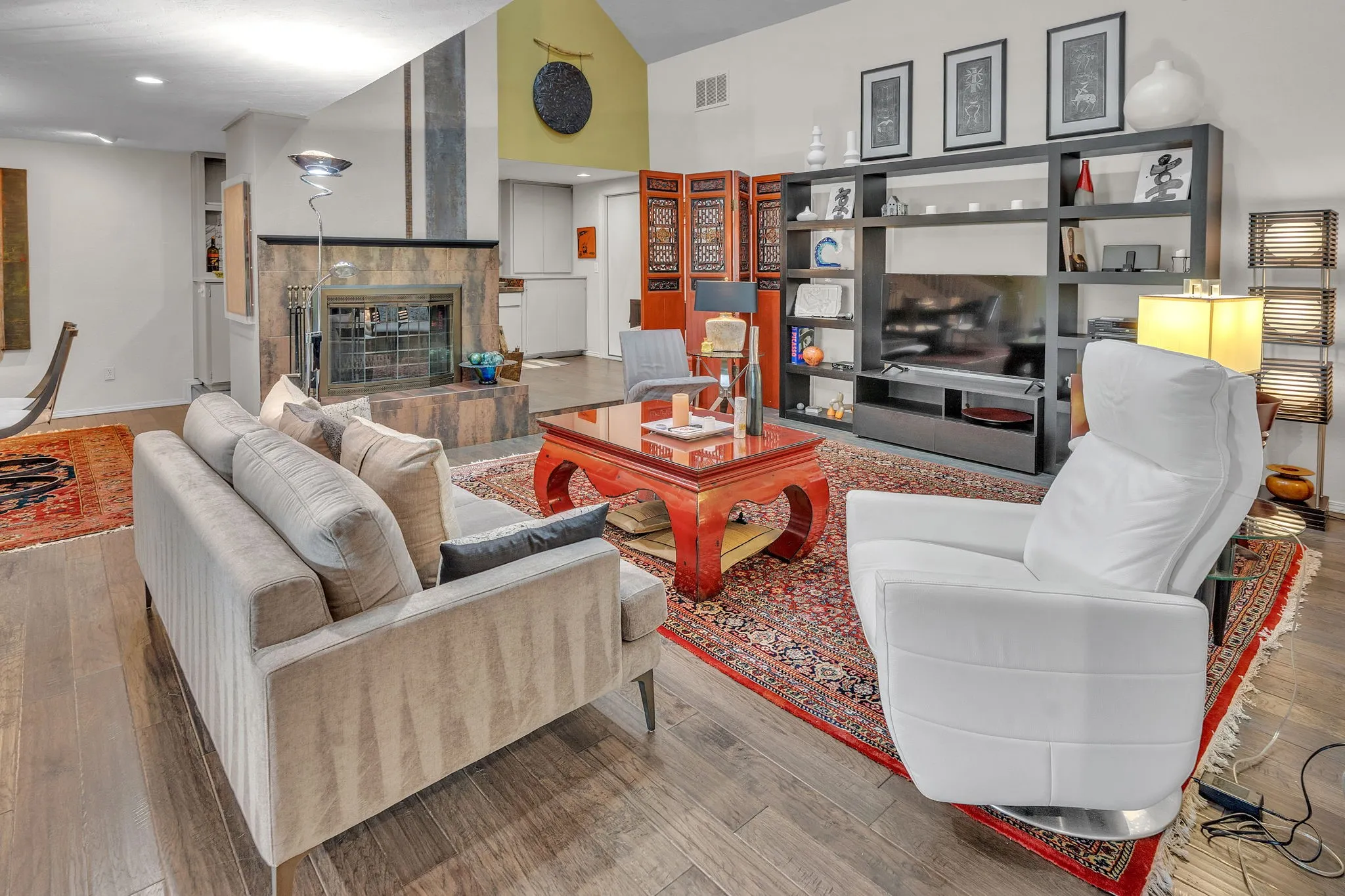 Living area with vaulted ceiling, skylight, & soaring fireplace