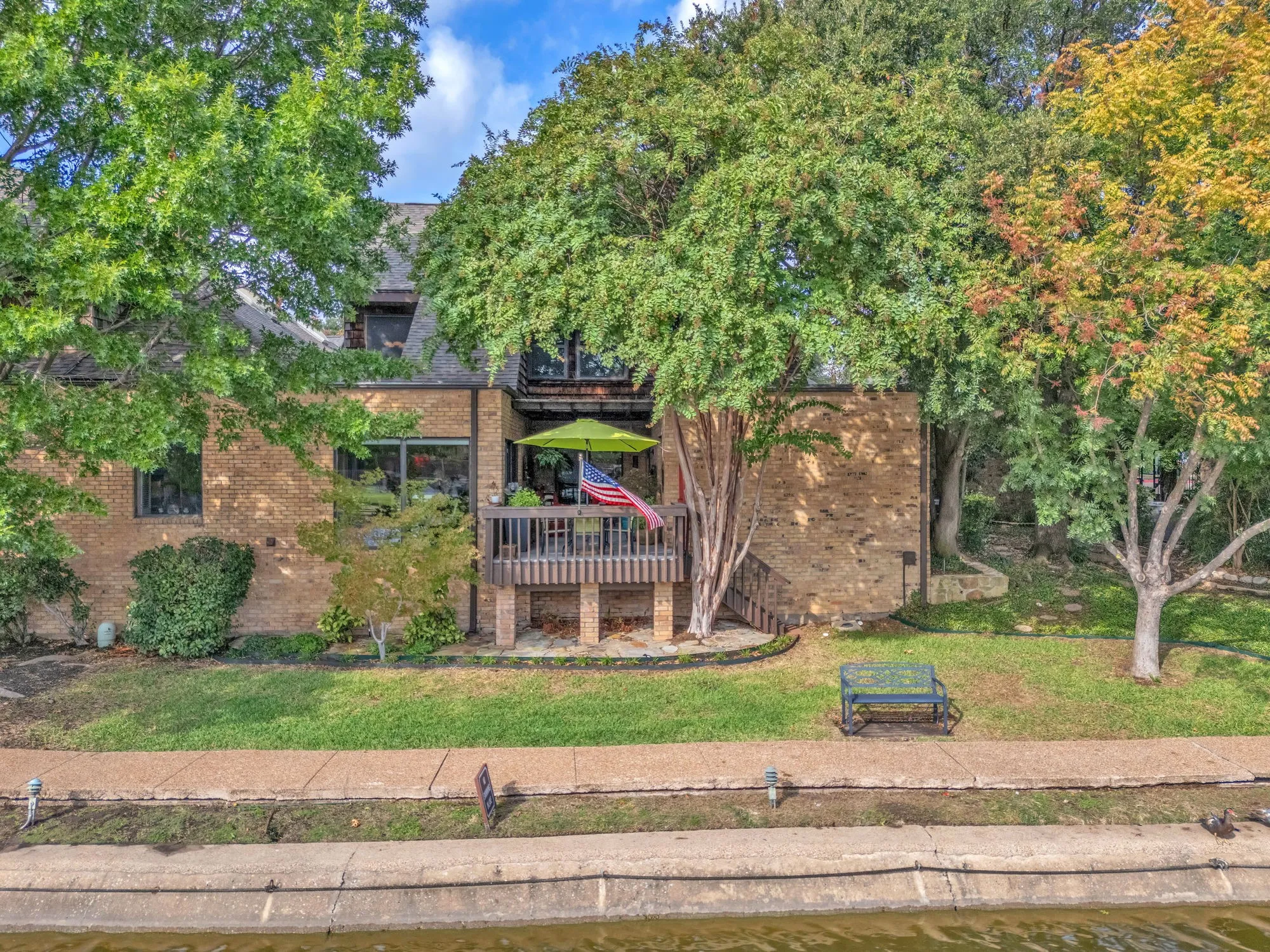 Back of structure with patio. Below deck new flagstone area.  Walking path for community.