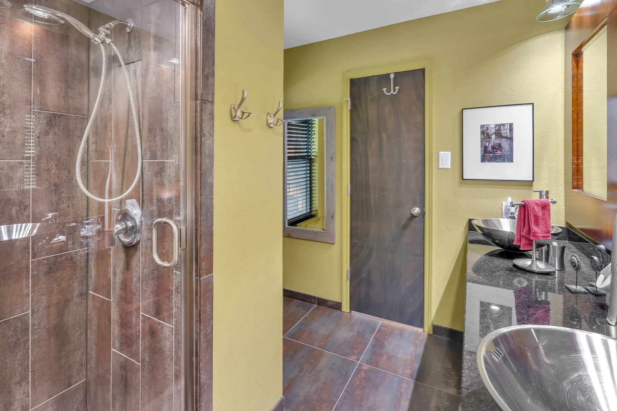 Upstairs bathroom with clear glass walk in shower and double stainless steel sinks.