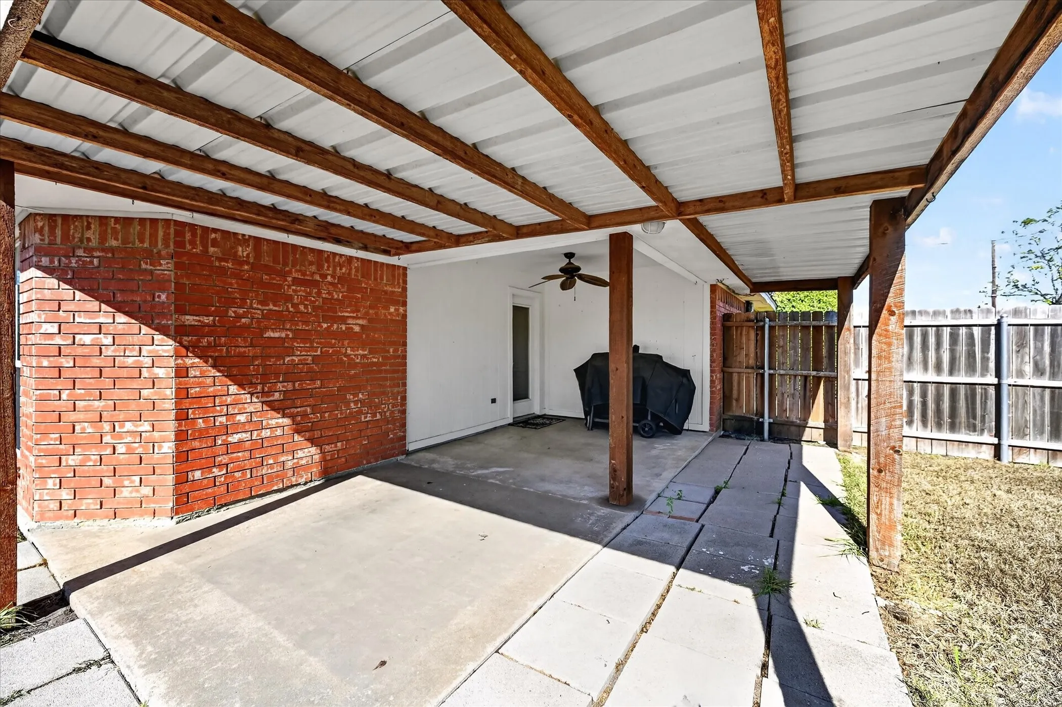 Covered patio featuring a metal roof, exposed wood beams, and a ceiling fan
