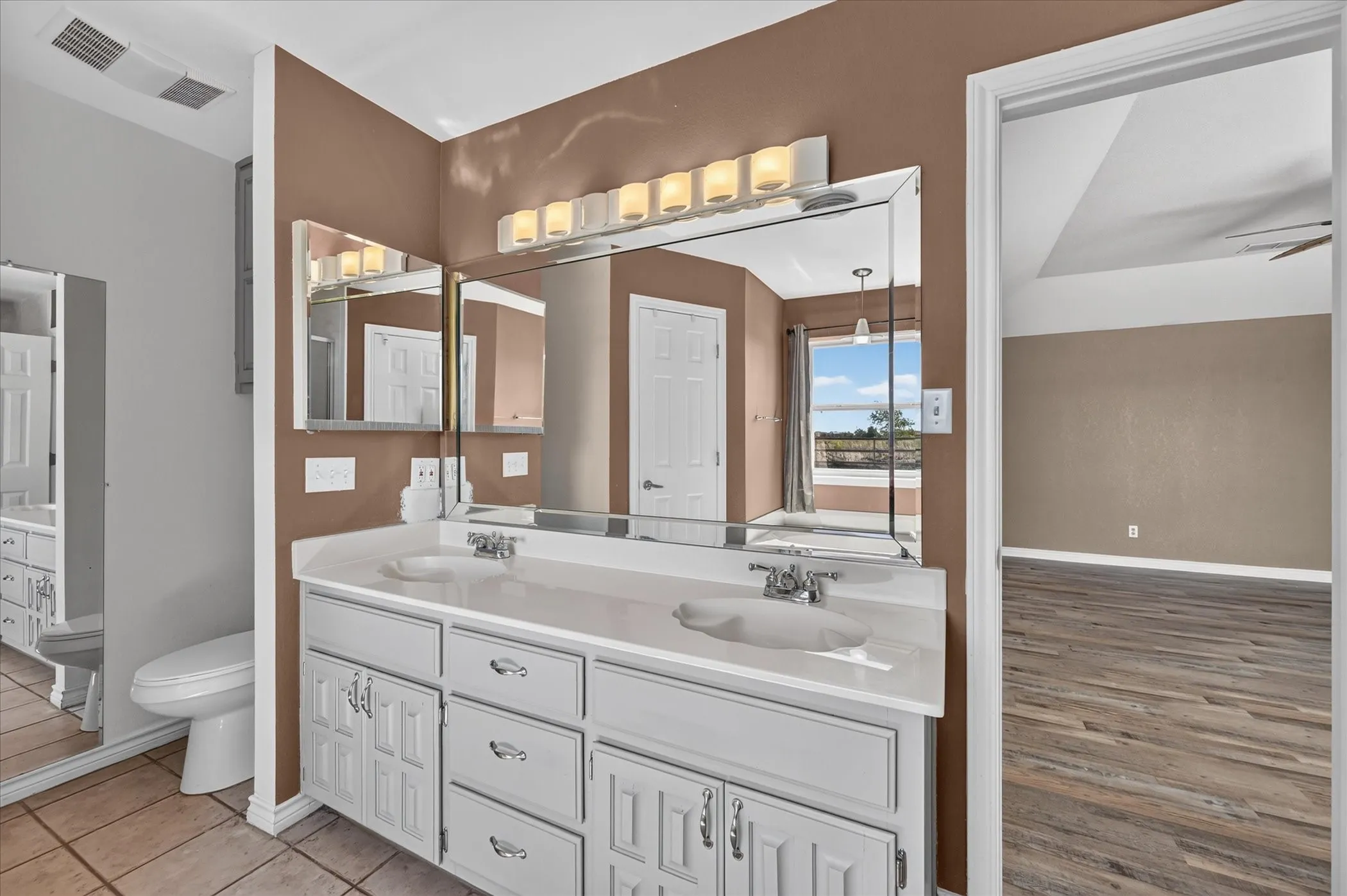 Dual vanity with white cabinetry, integrated sinks, and polished chrome faucets