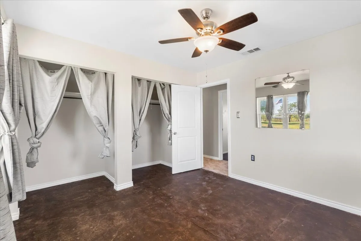 Smooth concrete flooring, ceiling fan with integrated lighting, window, and white​​‌​​​​‌​​‌‌​‌‌​​​‌‌​‌​‌​‌​​​‌​​ trim