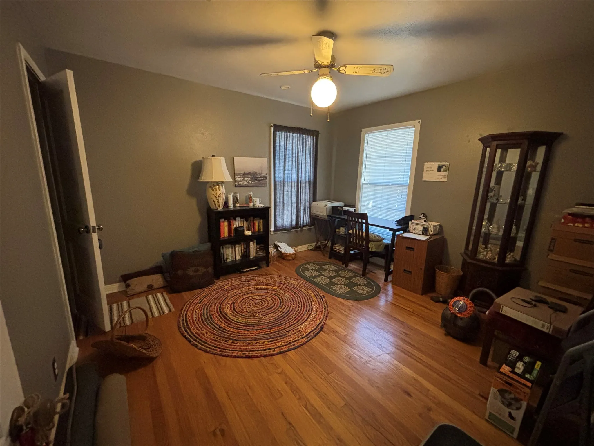 Hardwood flooring, painted walls, ceiling fan with integrated lighting, and a window for natural light