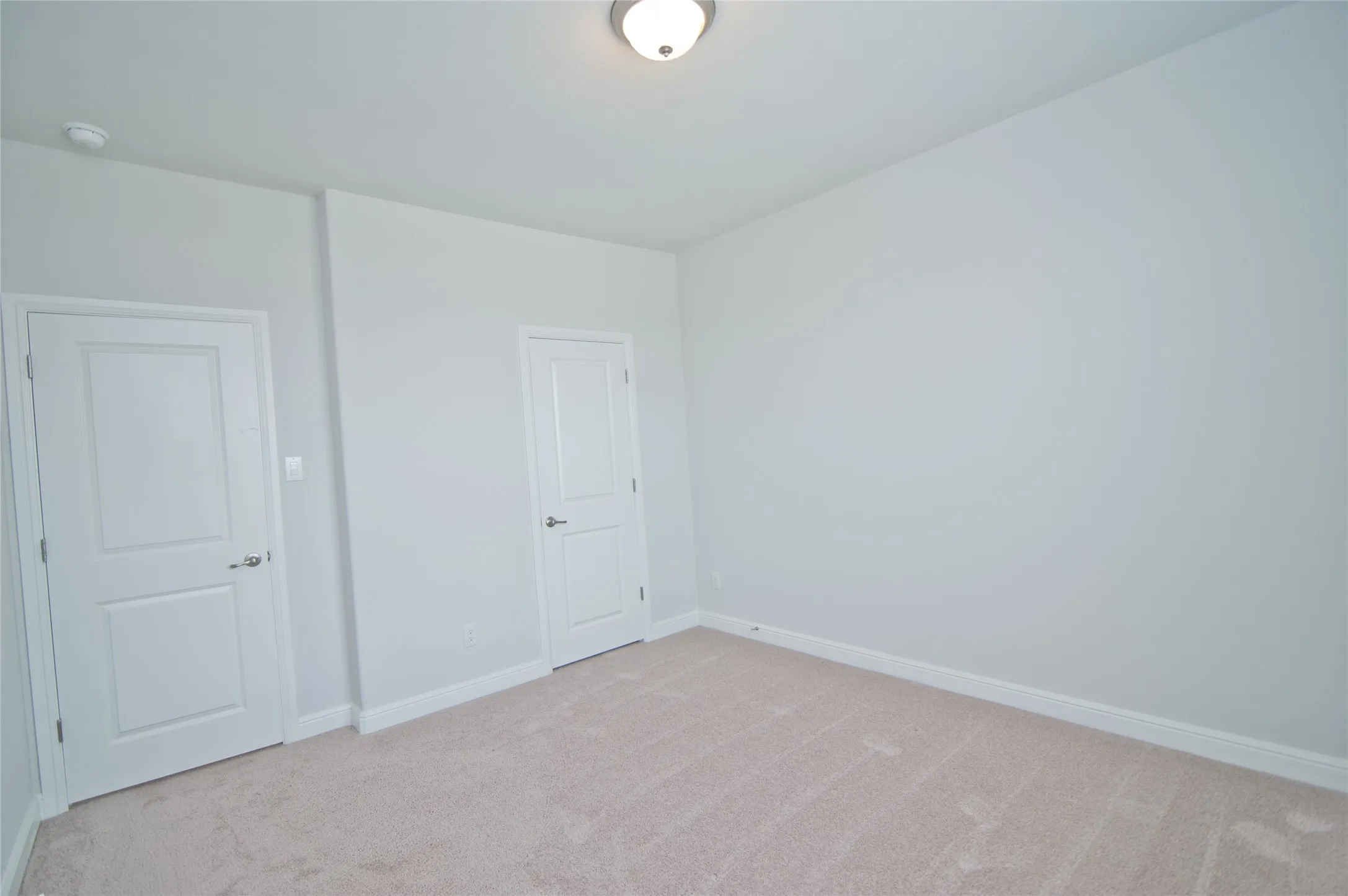 Neutral-toned carpeting paired with light-colored walls and white trim