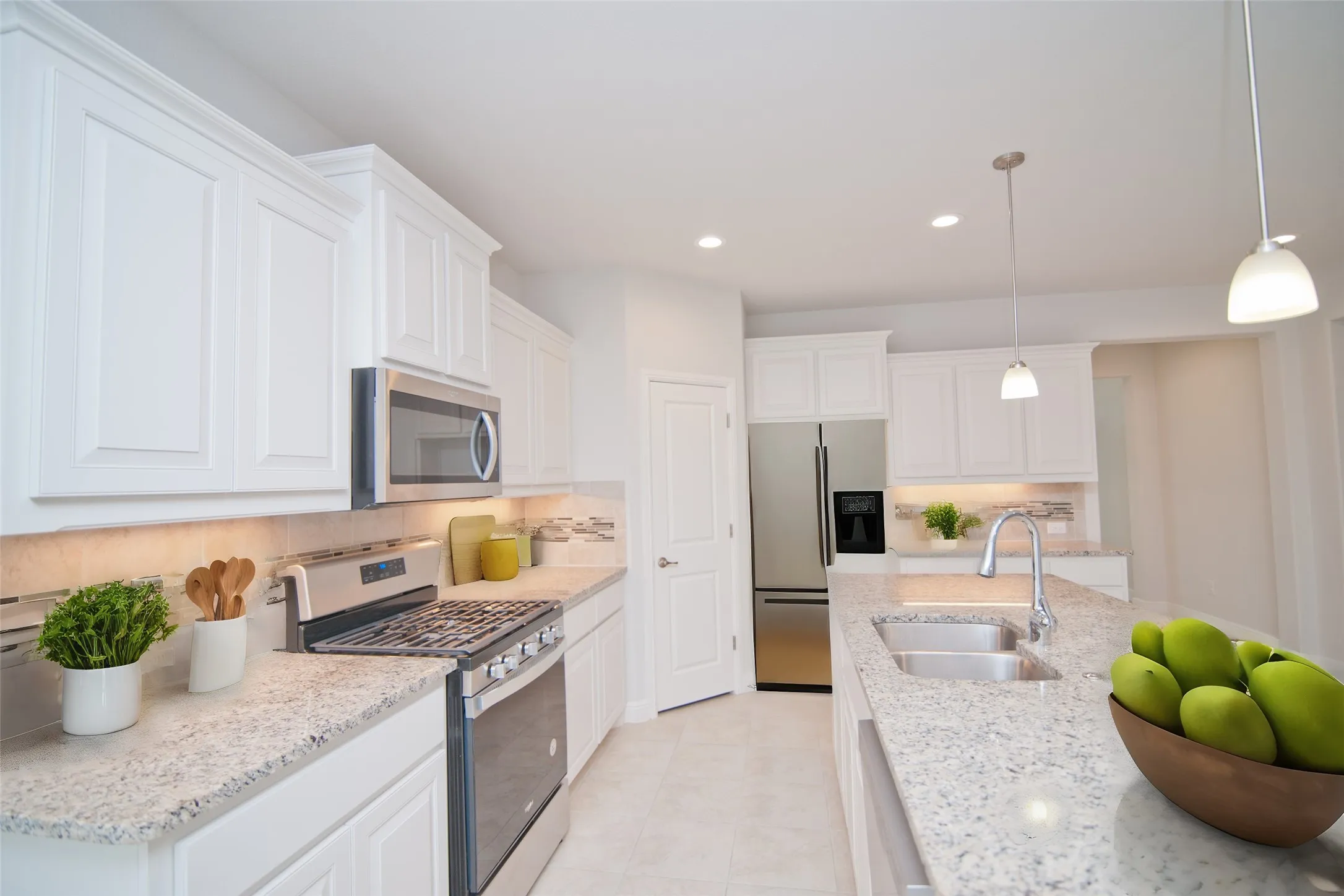 White cabinetry with crown molding, stainless steel appliances, granite countertops, tile backsplash, and recessed lighting