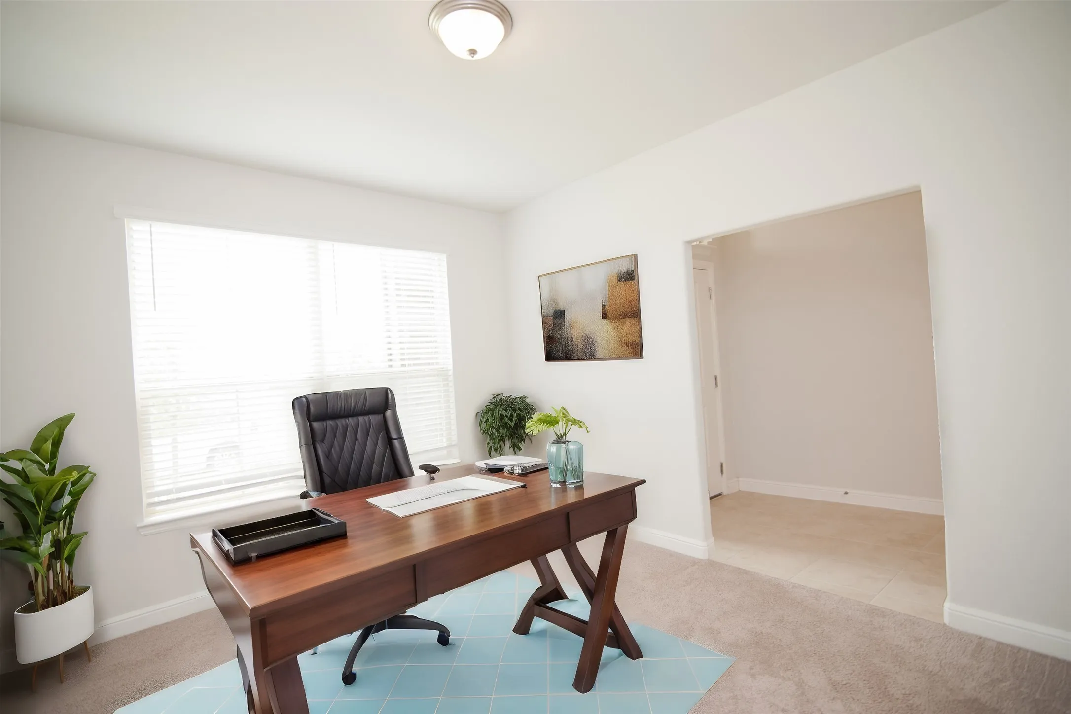 Recessed lighting, large window with blinds, neutral carpeting, and a broad arched doorway