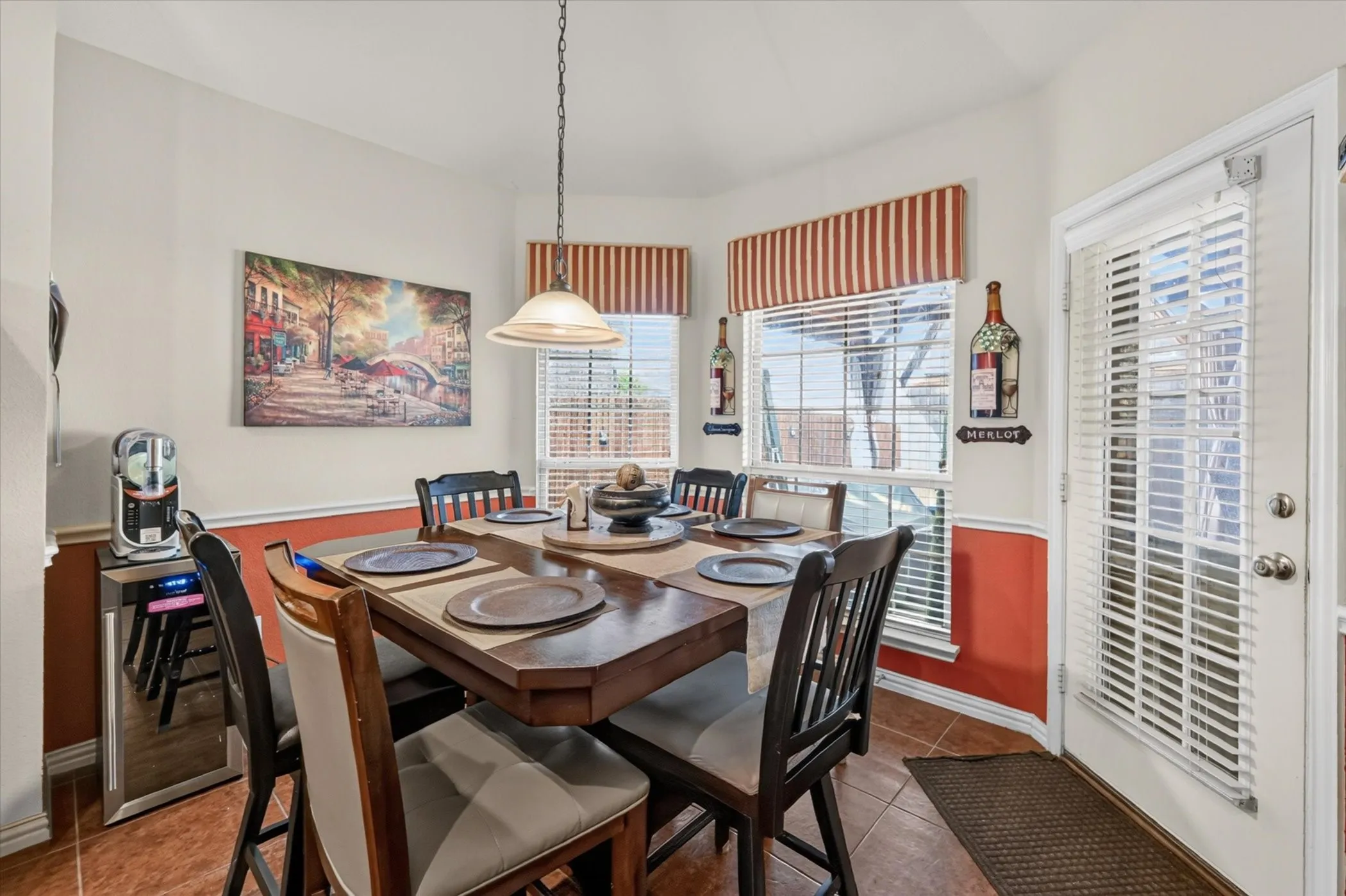 Dining area featuring a central chandelier, multiple windows with horizontal blinds, and a paneled white door