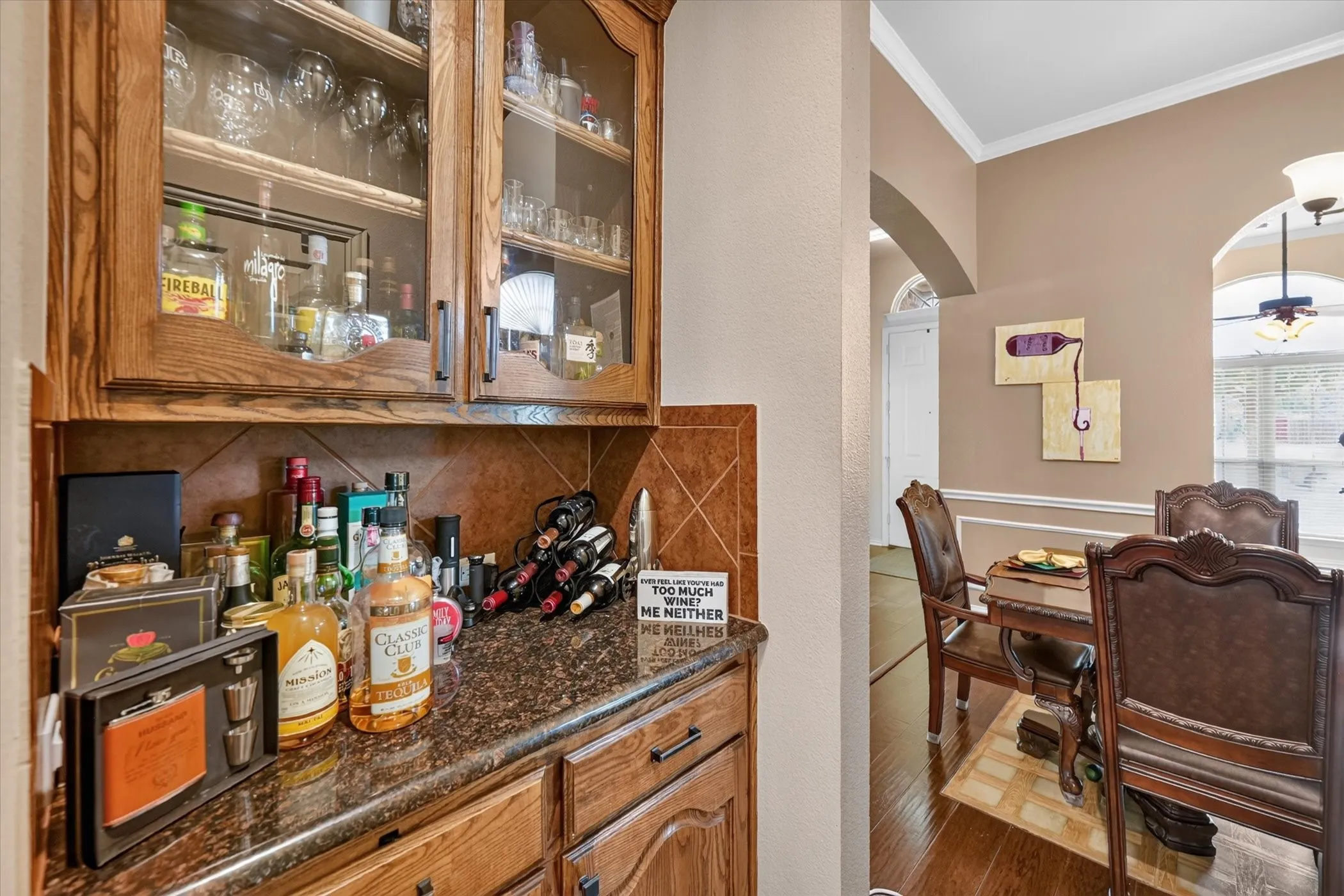 Built-in cabinetry with glass-front uppers, tile backsplash, and dark countertop