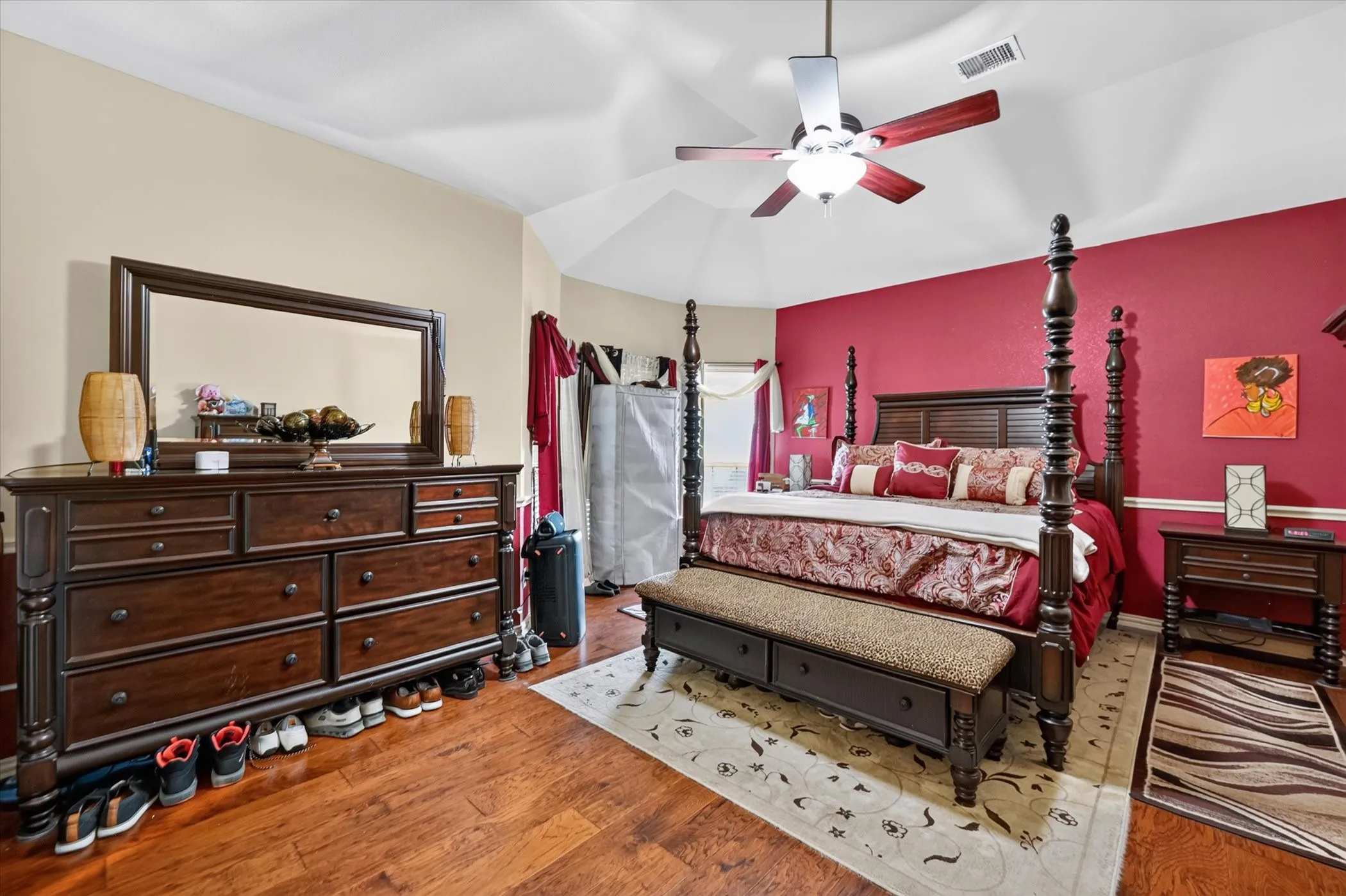 Tray ceiling with ceiling fan, wood-finish flooring, and painted accent wall
