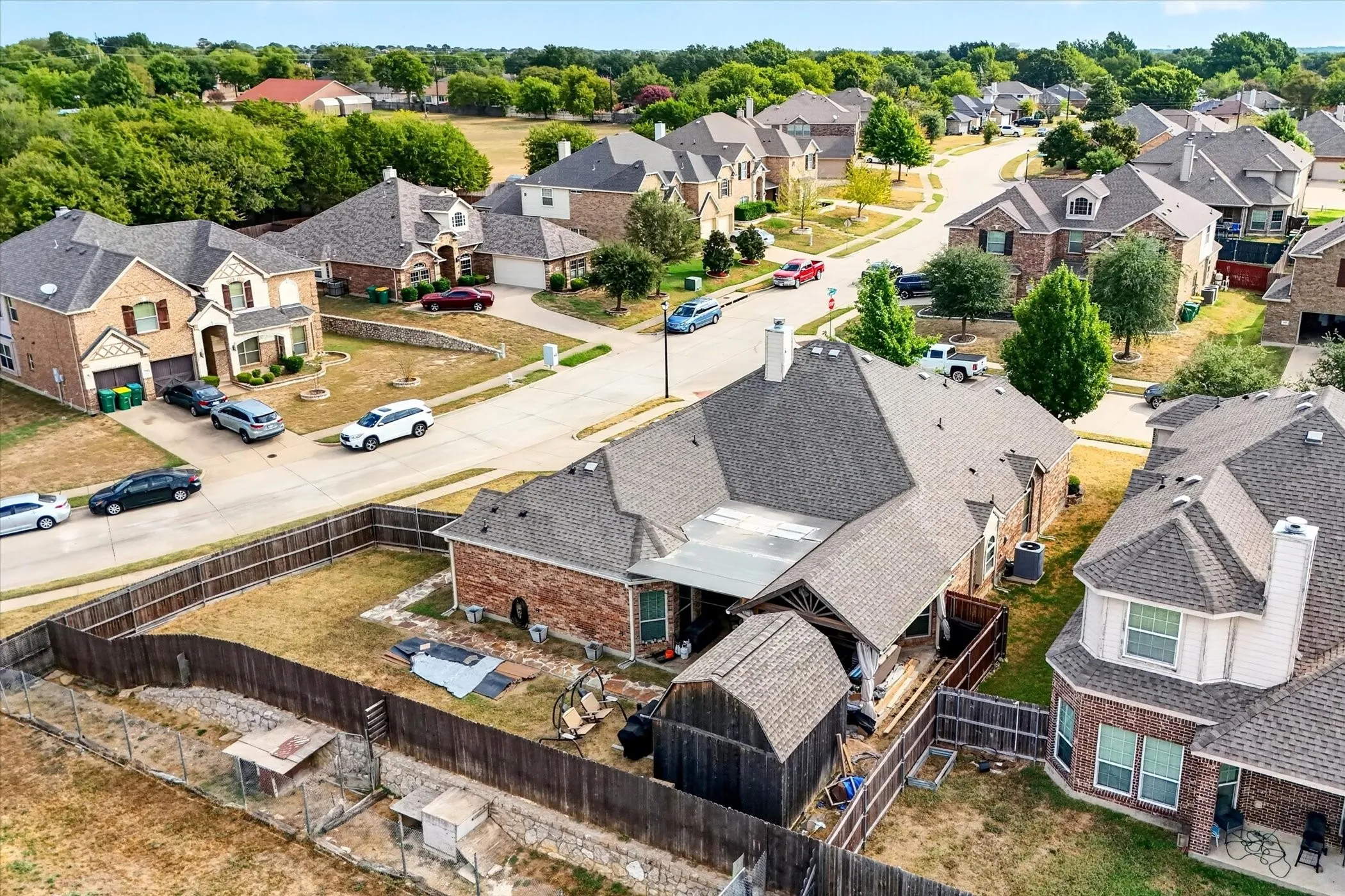 Brick veneer exterior with a covered patio and a wood fence