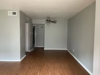 Wood-finish flooring, neutral gray wall tones, white trim, and a ceiling fan