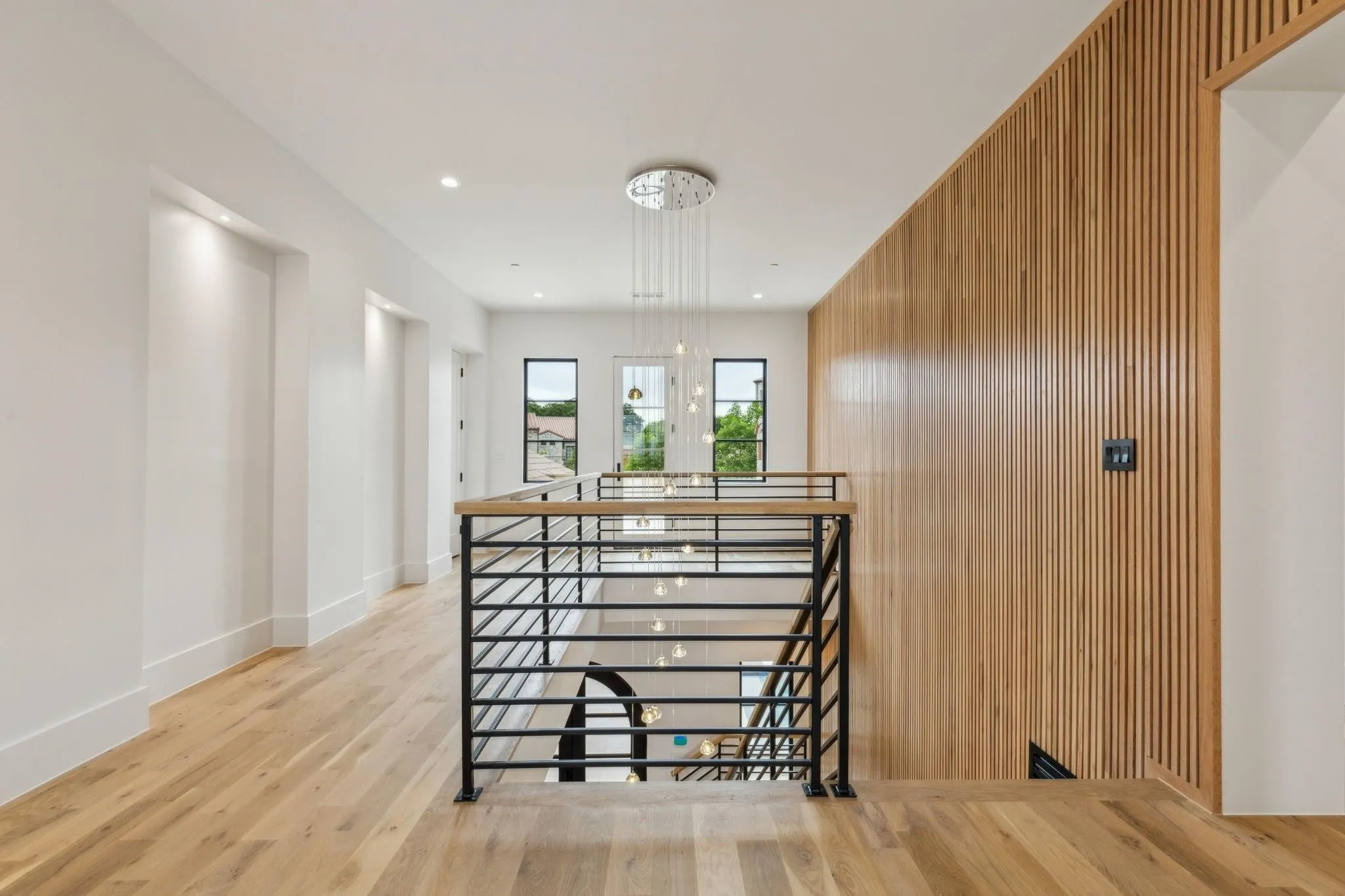 Staircase featuring wood finished floors, wood paneled accents on walls and baseboards