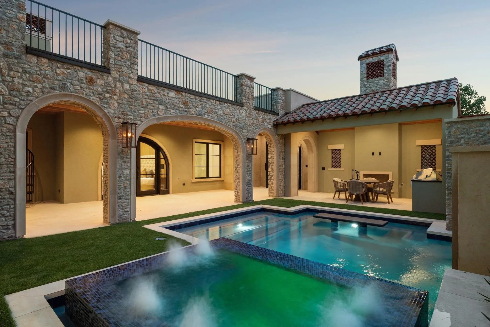 Courtyard view of house featuring a large balcony, a patio, a tile roof, and a pool with connected hot tub