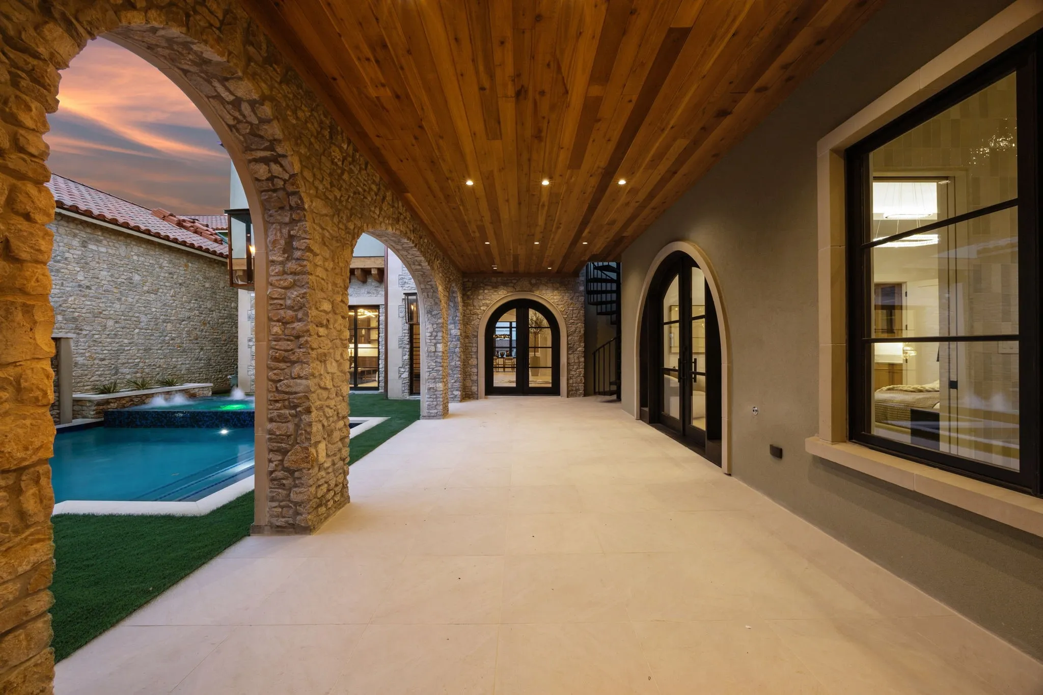 Courtyard view of house featuring a large balcony, a patio, a tile roof, and a pool with connected hot tub
