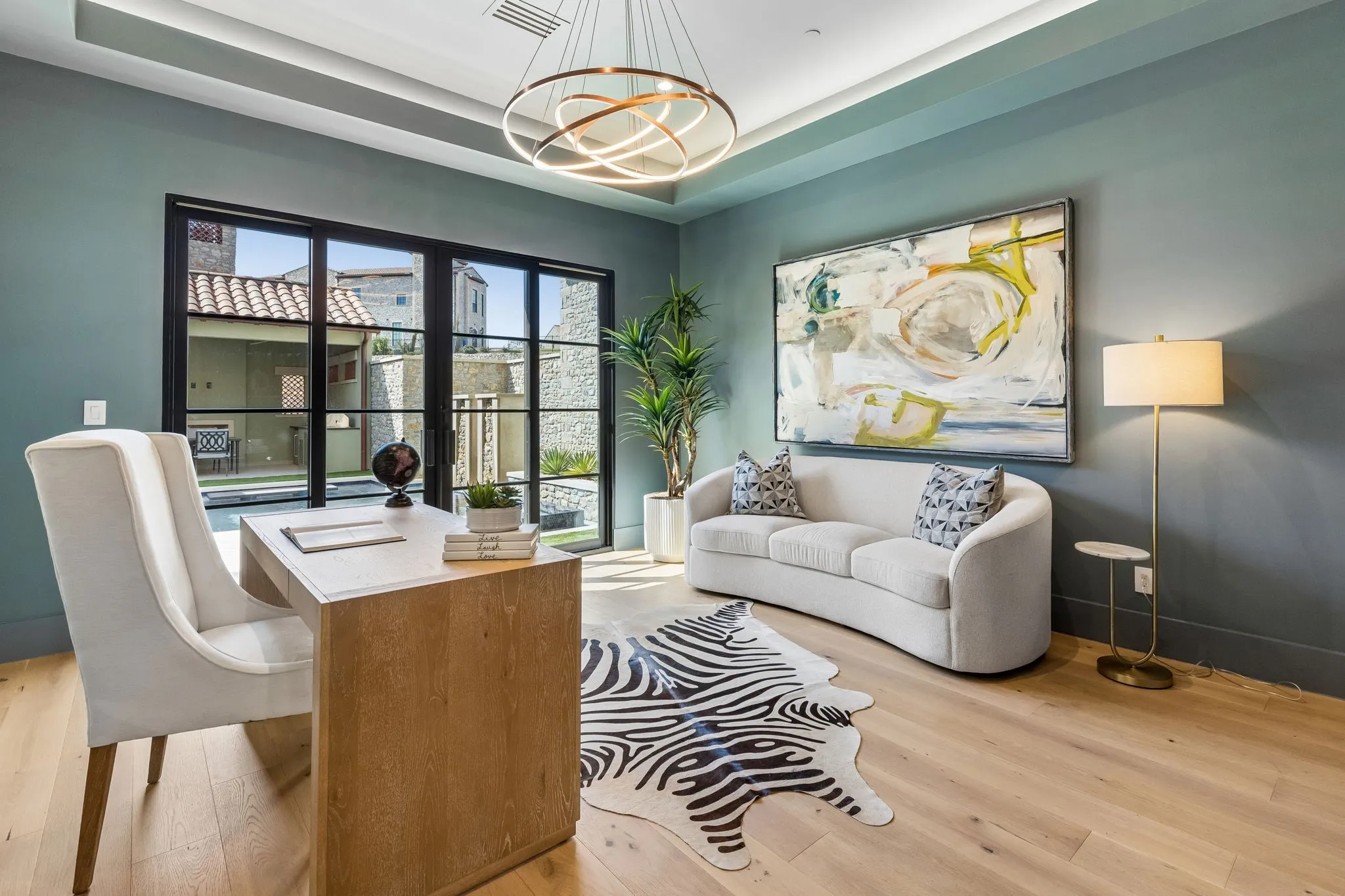 Office or flex room with white oak flooring, sliding iron & glass doors leading to courtyard, Tray ceiling with lighting and designer lighting