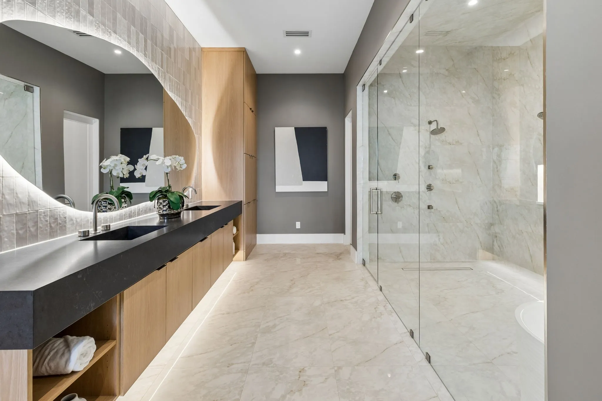 Spacious Bath oasis with designer mirrors and lighting, built-in cabinetry, lighting under cabinetry, duel shower, Hollywood soaking tub, and tile floors