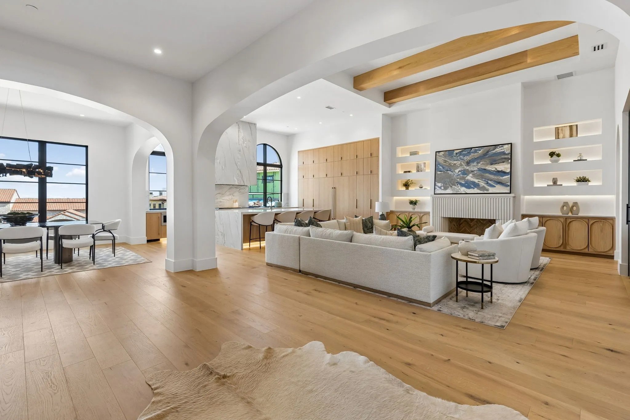 Living area with built in features, white oak wood floors, recessed lighting, a cast stone fireplace, and beamed ceiling