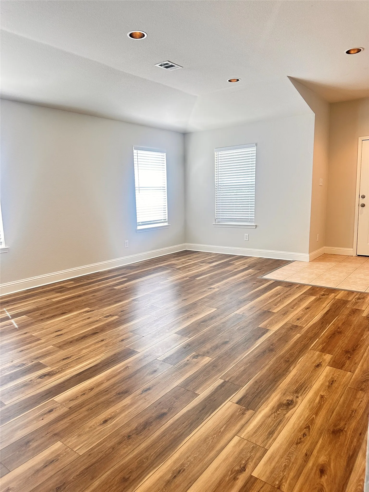 Empty room with light wood-type flooring and recessed lighting
