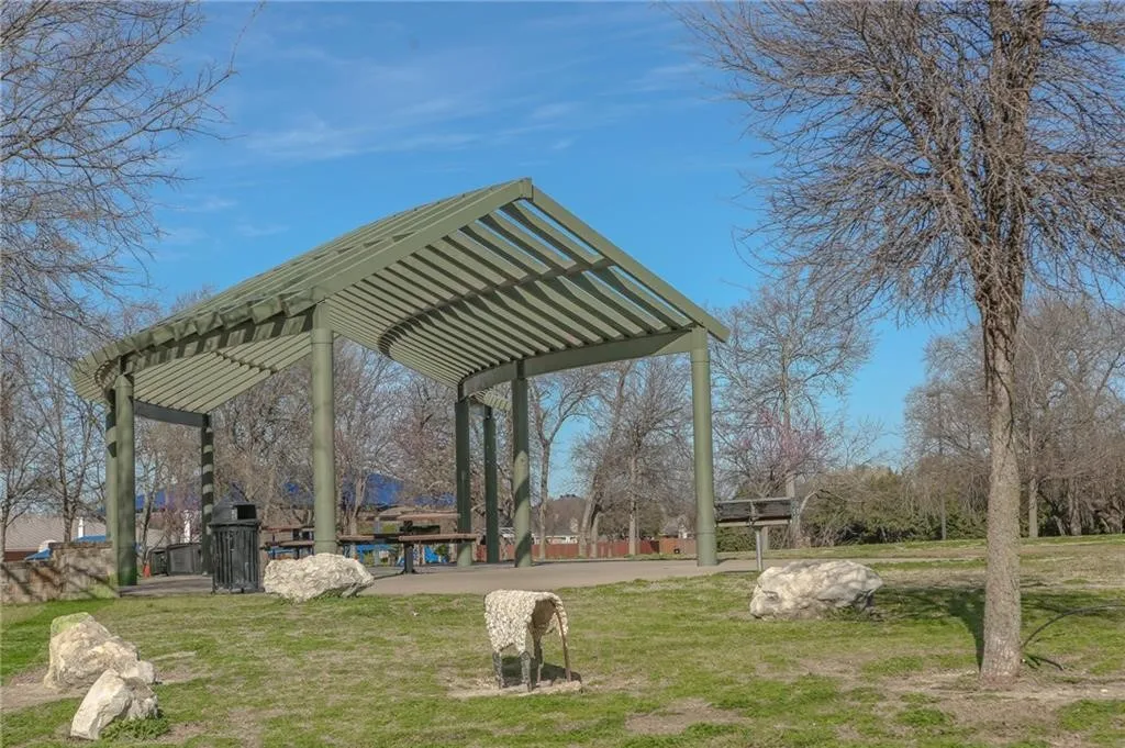 View of community featuring a pergola, a lawn, and a patio