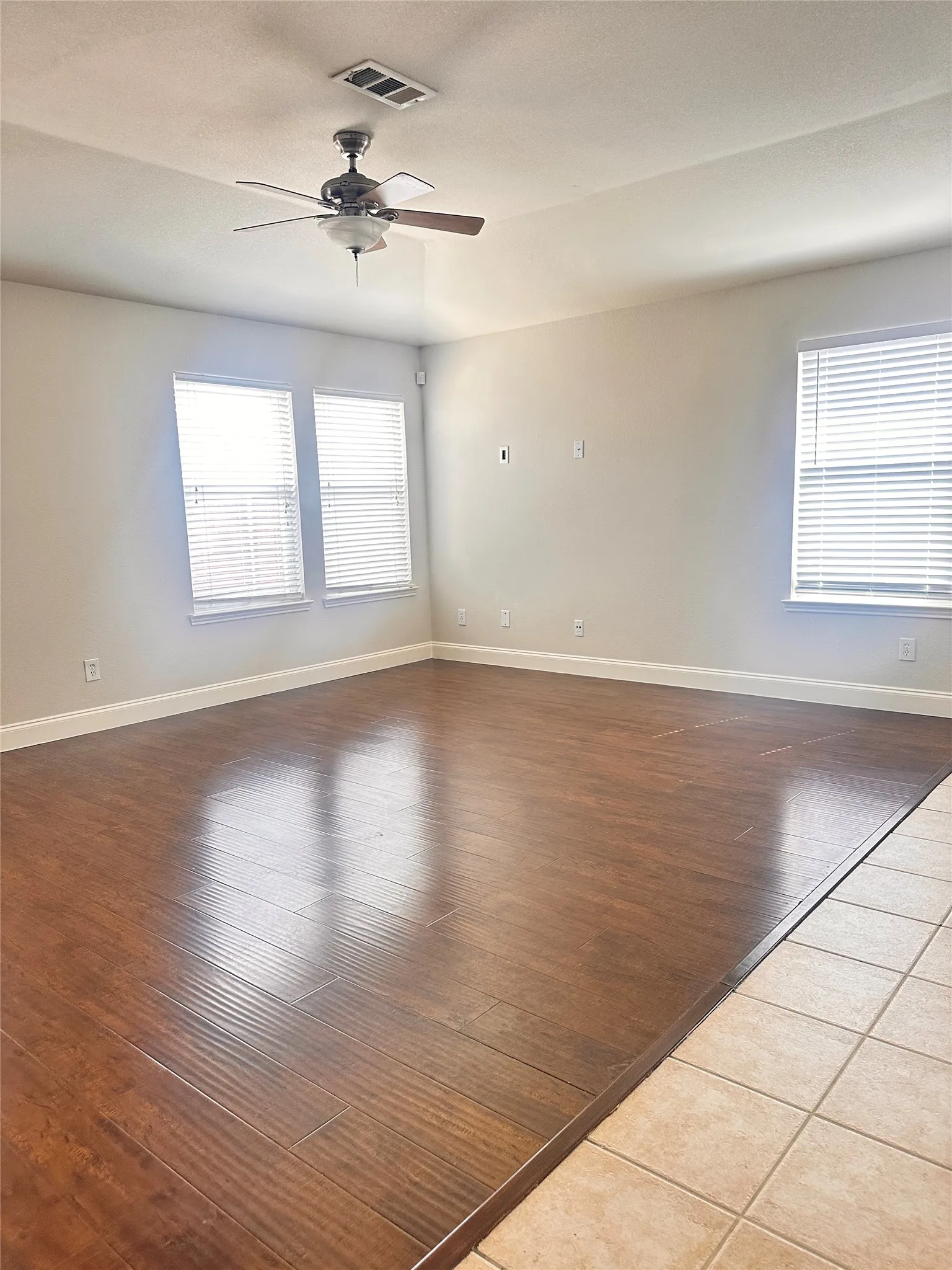 Spare room with dark wood-type flooring, ceiling fan, and a textured ceiling