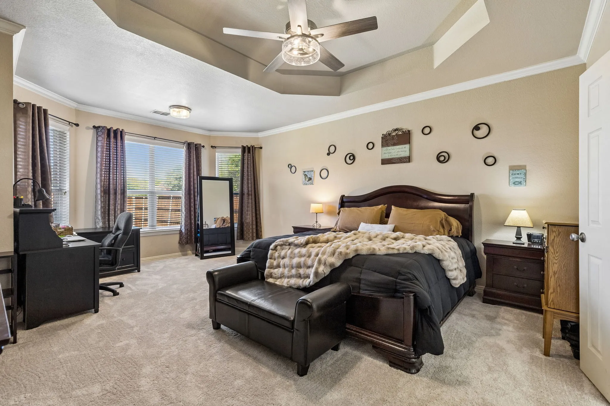 An Owner's Suite That Truly Feels Like a Retreat – Exceptionally spacious, the primary bedroom features new carpeting, a distinctive tray ceiling, updated ceiling fan with lighting, and a generous sitting area currently used as a home office