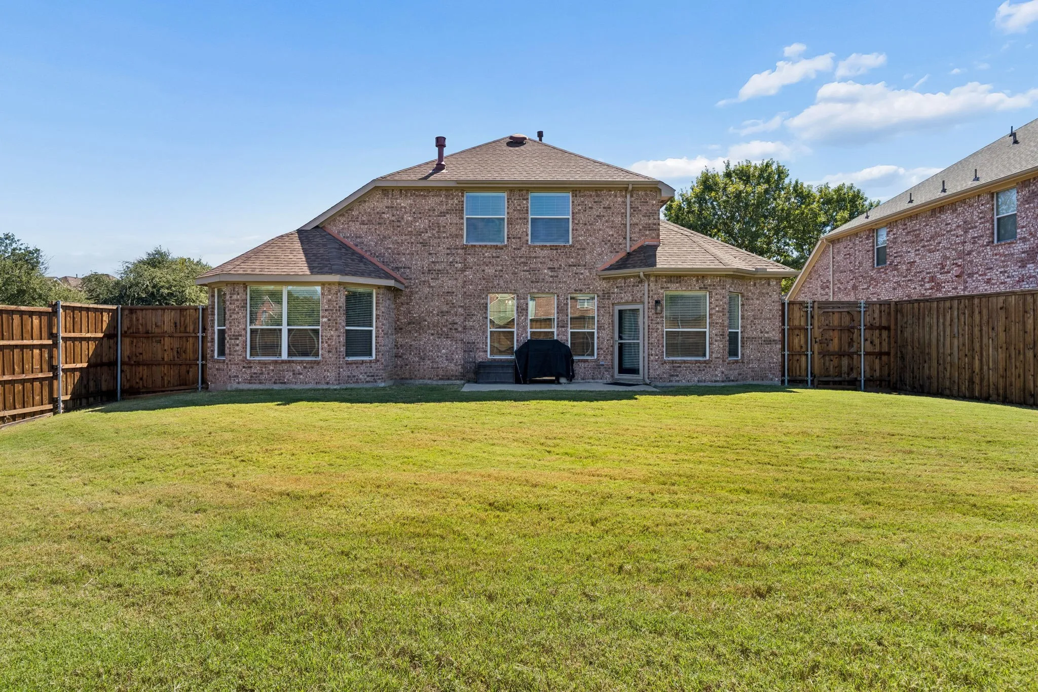 Plenty of Room to Enjoy the Outdoors – The home's attractive brick rear elevation overlooks a spacious fenced backyard, with multiple windows bringing natural light into the interior. A patio just outside the back door provides a convenient starting point for outdoor dining and entertaining.