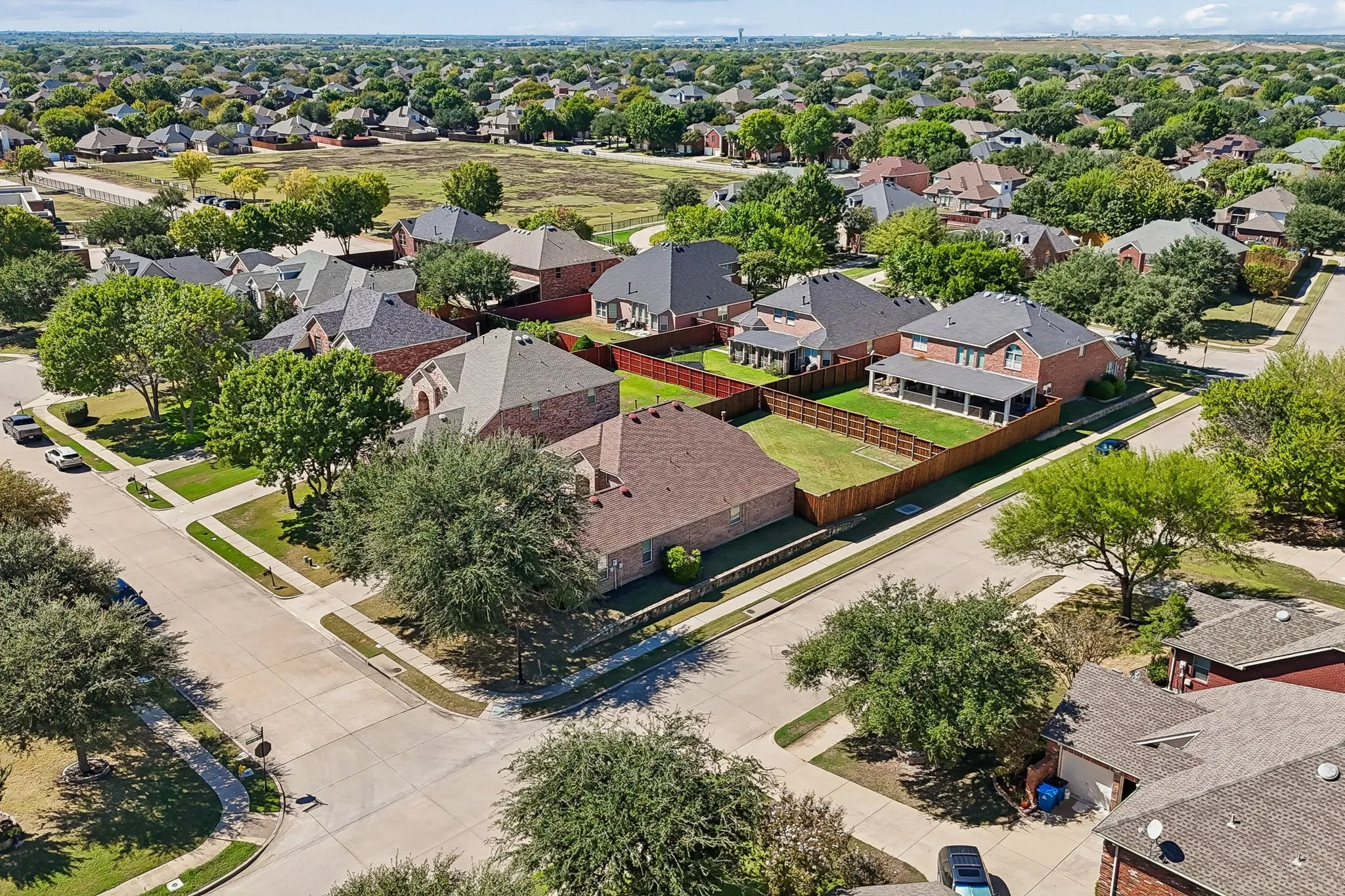 A Great Setting in Waterview – This aerial view highlights the home's desirable interior corner-lot location within an established neighborhood of attractive brick homes, mature trees, and sidewalks. Liberty Grove Elementary is just five houses away, with a pedestrian walkway at the end of the cul-de-sac.