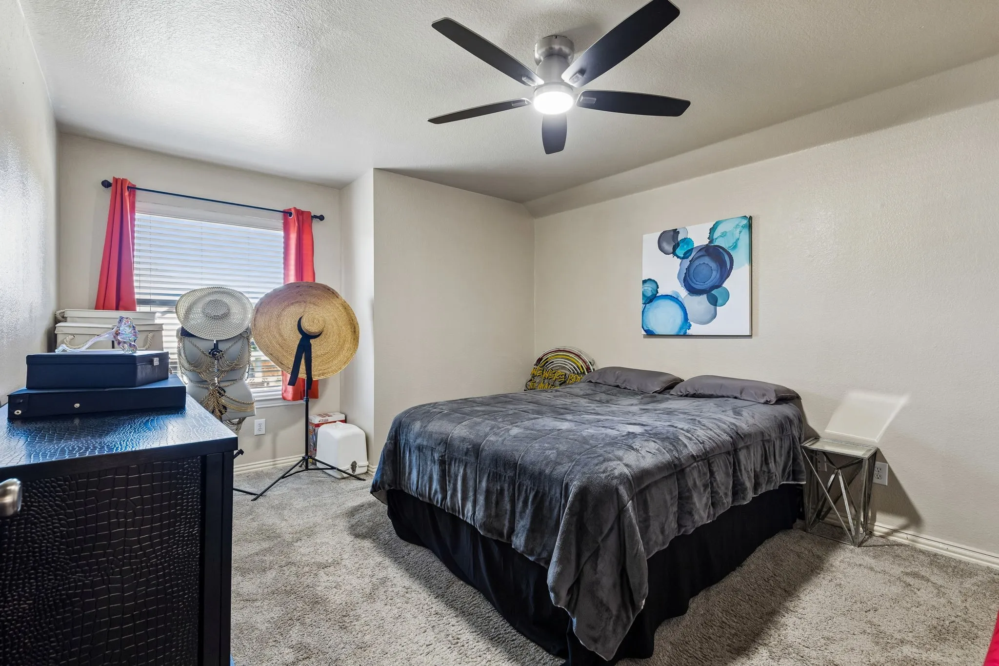 Generously Sized Secondary Bedroom – This spacious upstairs bedroom features soft carpeting, a large window for natural light, and an updated ceiling fan with integrated lighting, offering a comfortable space with flexible furniture arrangements