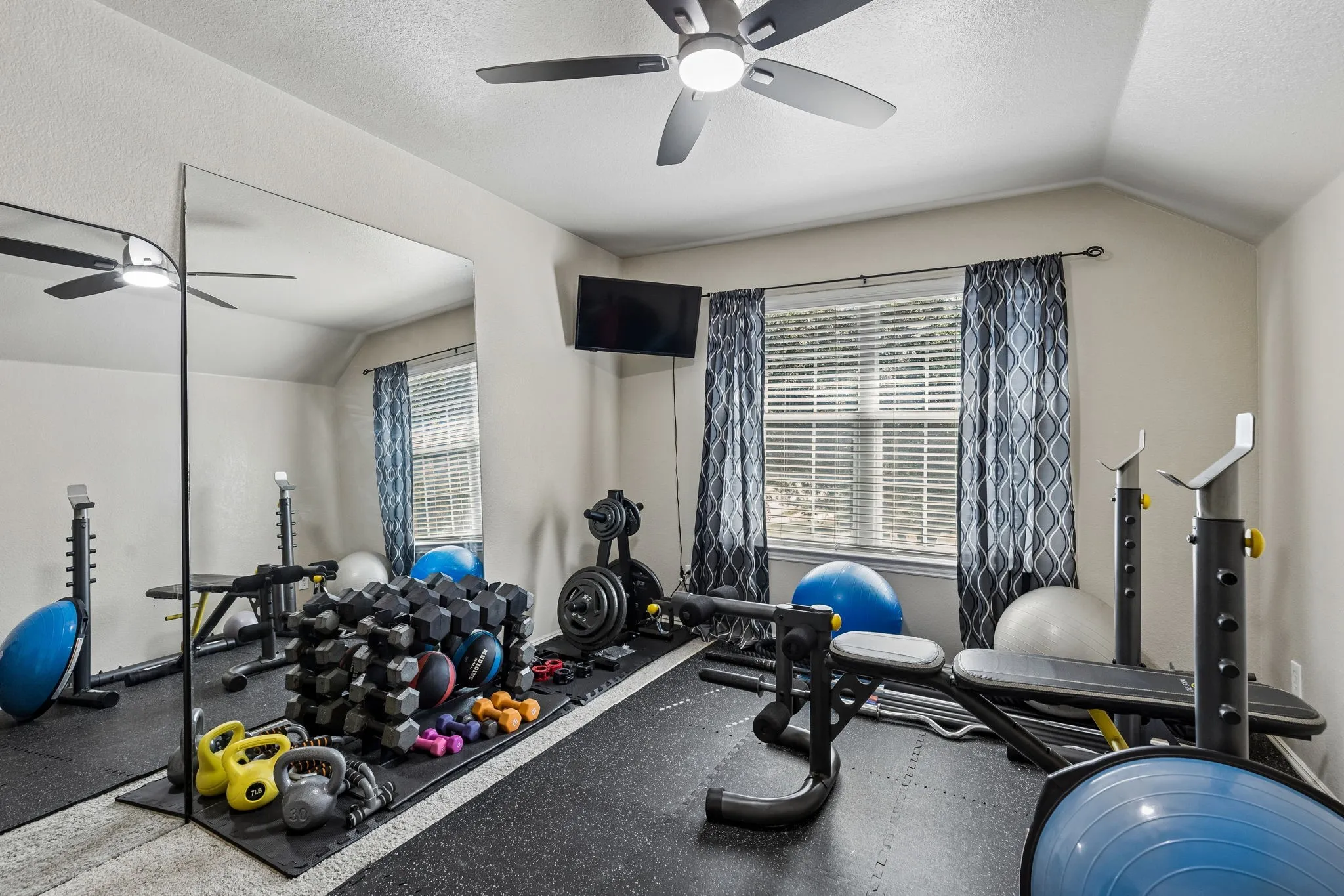 Flexible Space with Architectural Character – This upstairs bedroom features an interesting sloped ceiling, comfortable carpeting, and an updated ceiling fan with lighting. Its practical layout allows for a variety of bedroom or workspace configurations.