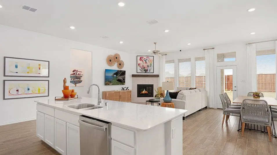 Kitchen island with an undermount sink, stainless steel dishwasher, and light-toned countertop