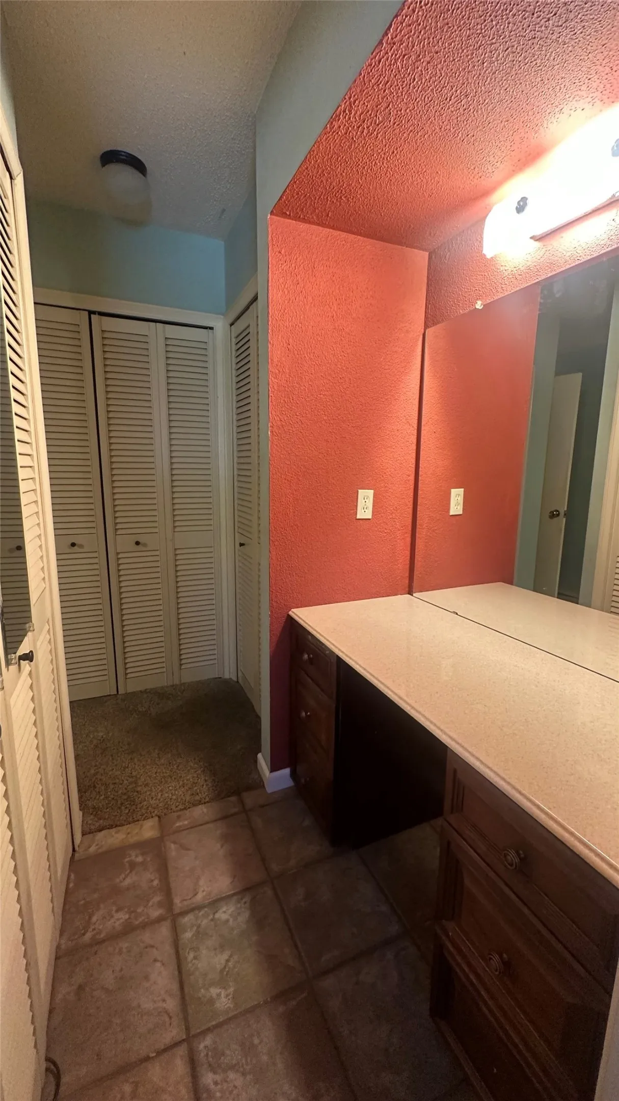 Primary bathroom/BR multiple louvered closet doors and the dressing & make-up table (no sink).