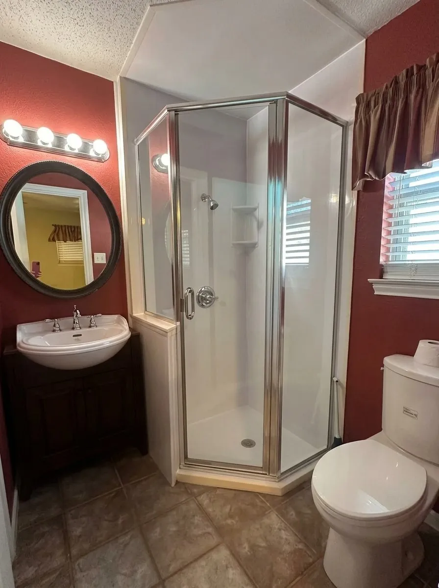 Offers updated shower with glass enclosure, commode and sink/cabinet and mirror, lighting.