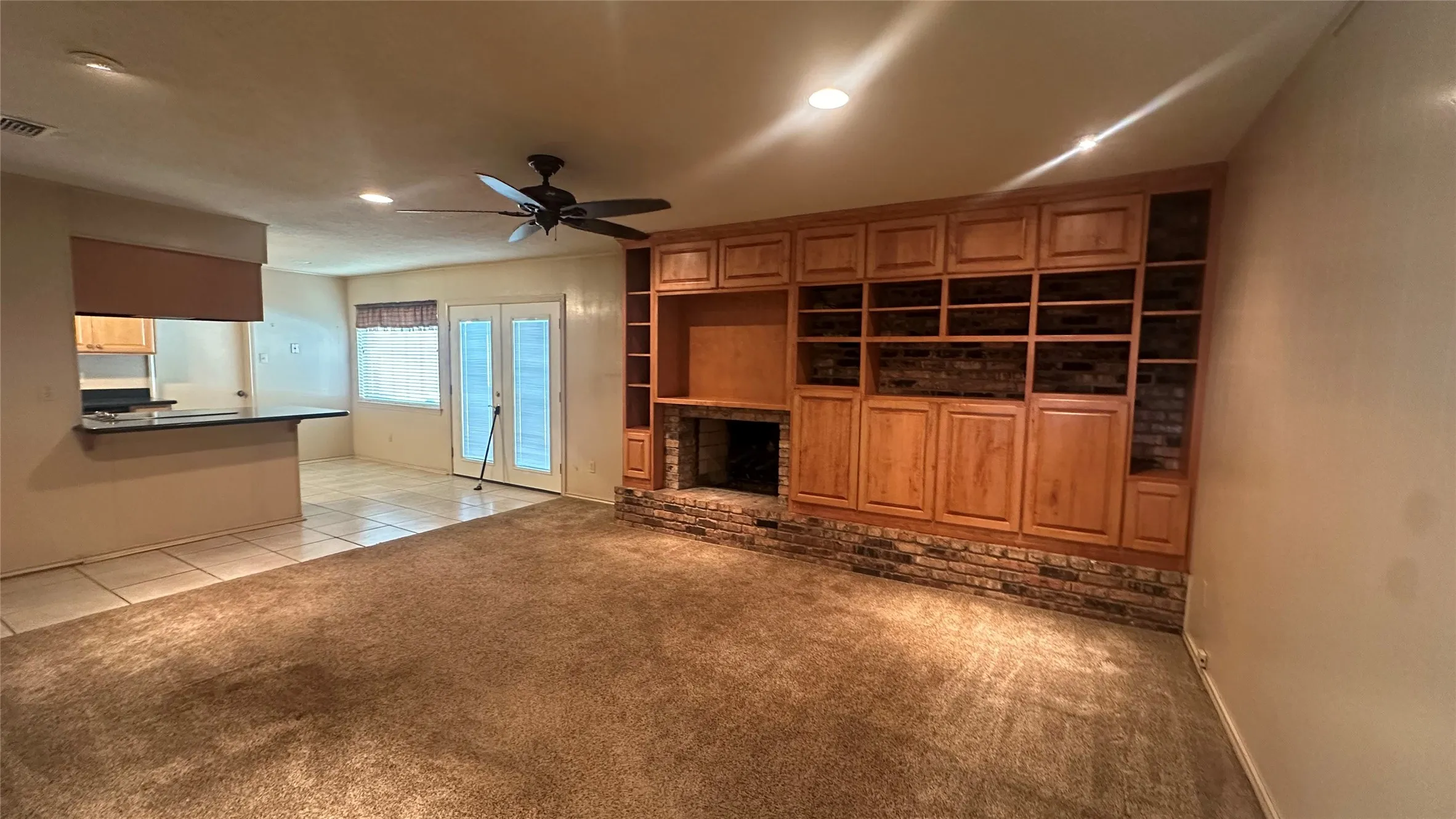 vacant view of den, fp, entertainment and towards the kitchen & breakfast area.