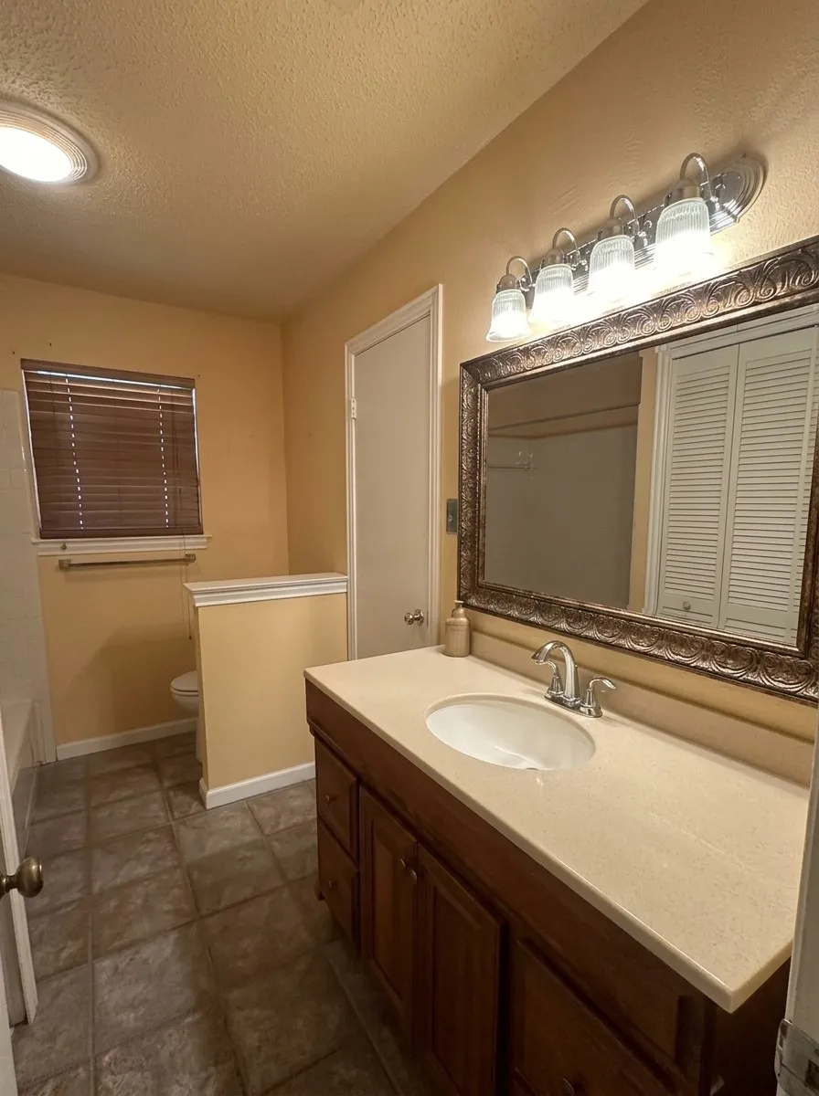 Integrated bathtub/shower combo  with a tile surround, chrome fixtures.