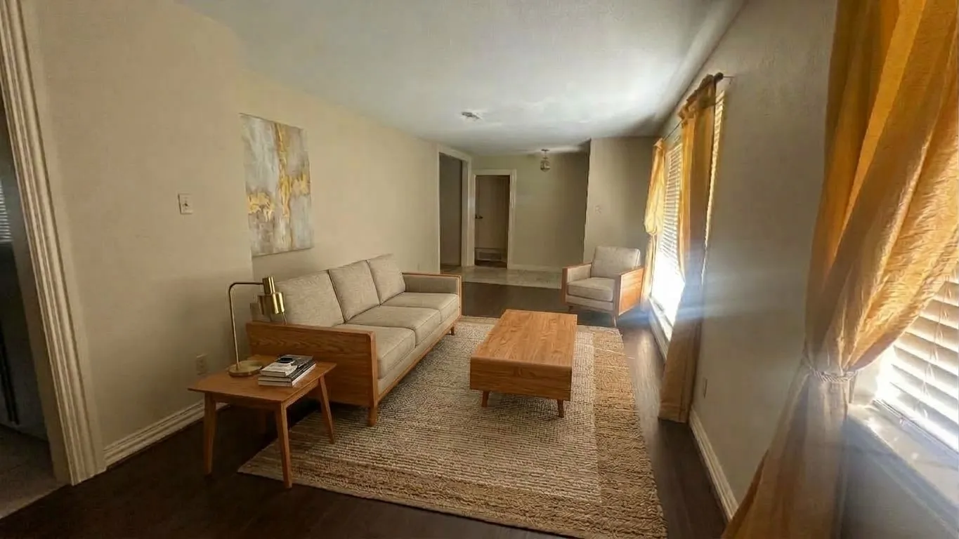Staged AI furniture;  Living area featuring a floor-to-ceiling built-in wood cabinetry, brick fireplace, and a ceiling fan