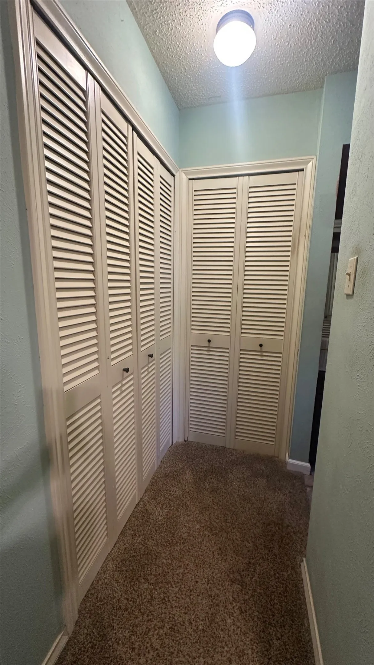 Closet area and enters into the dressing area with cabinetry and make-up table.