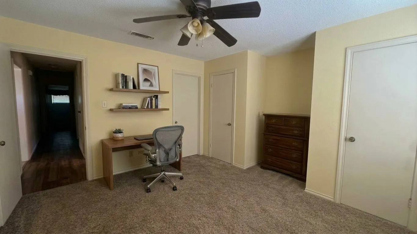 Staged AI furniture;  Ceiling fan, carpet, two panel closet doors, and direct access to bathroom.