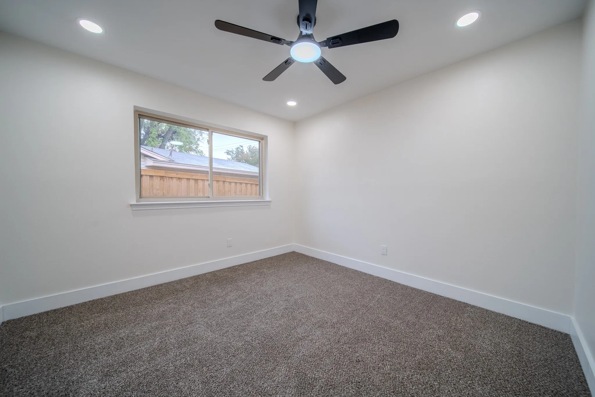 Recessed lighting, ceiling fan, neutral wall paint, window, and carpeting