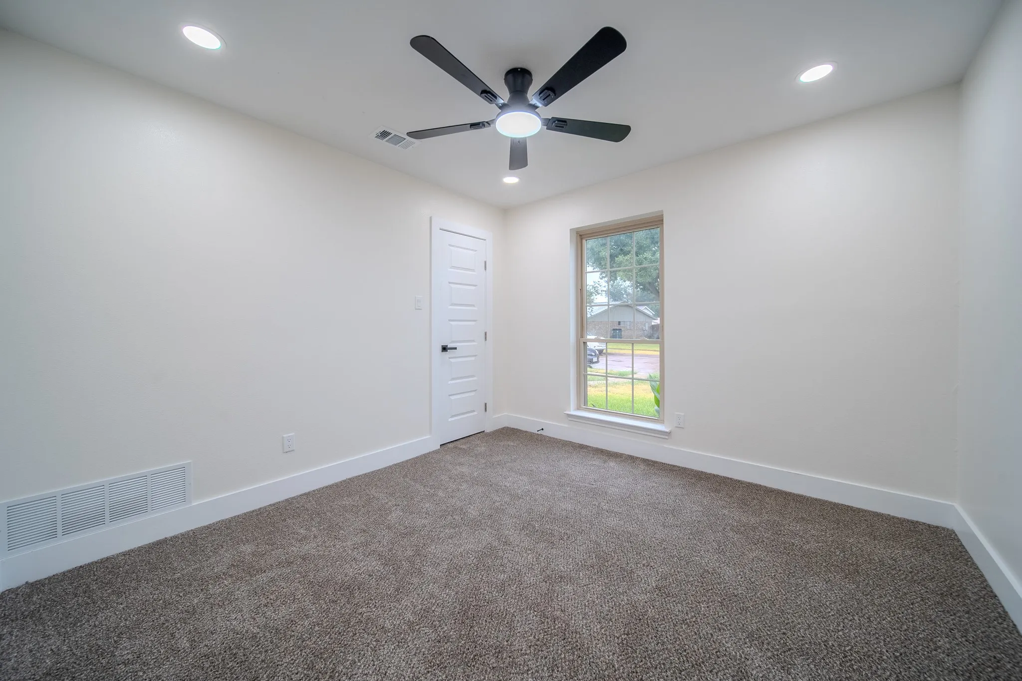 Recessed lighting, ceiling fan with light, carpeted flooring, single window, and a paneled door