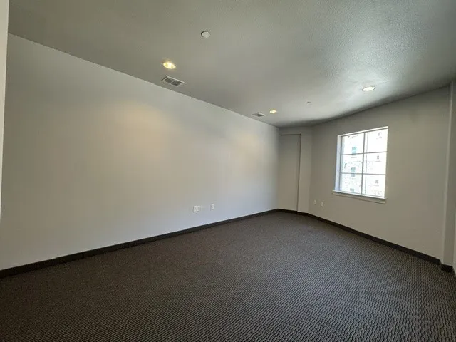 Recessed lighting, window with grid panes, wall-to-wall carpeting
