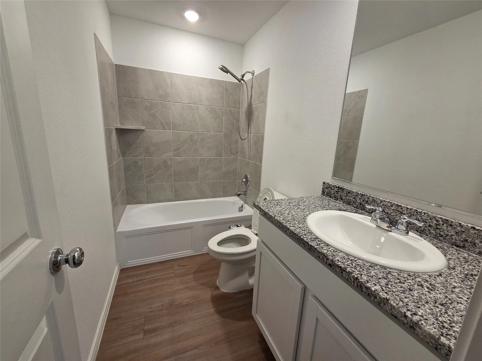 Bathroom featuring a single vanity with stone-finish countertop, undermount sink, and polished chrome faucet