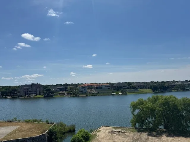 Waterfront setting featuring a broad expanse of water and a distant treelined shore with residential properties