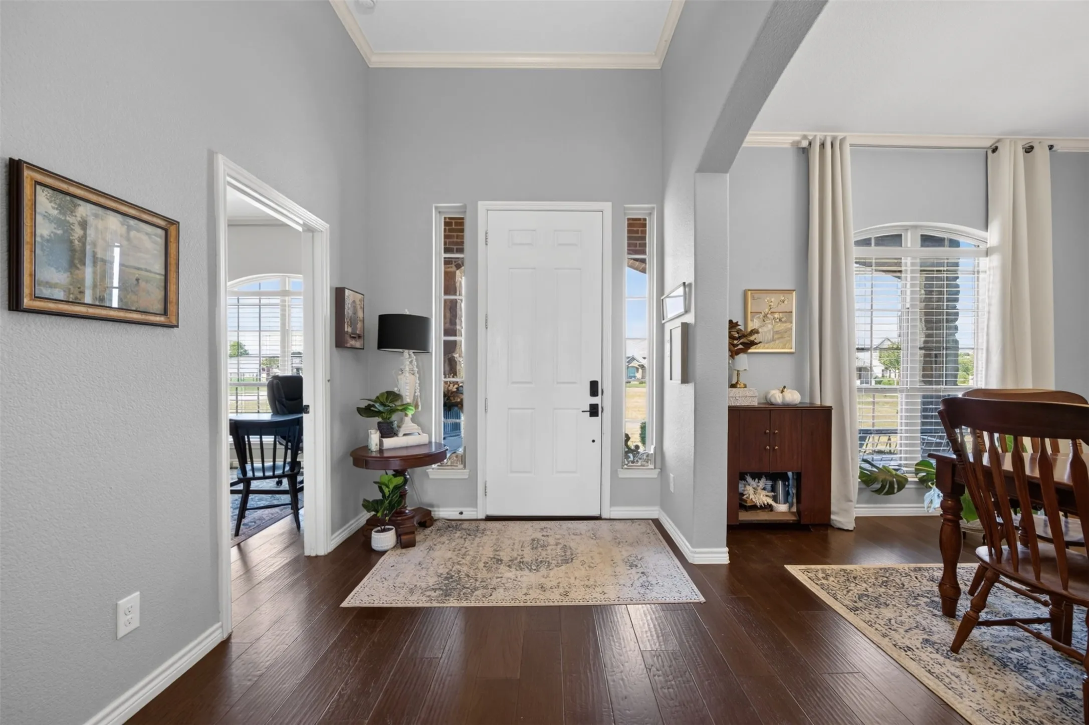 Entryway featuring dark wood-finish flooring, a white paneled door with sidelight windows, and light gray walls