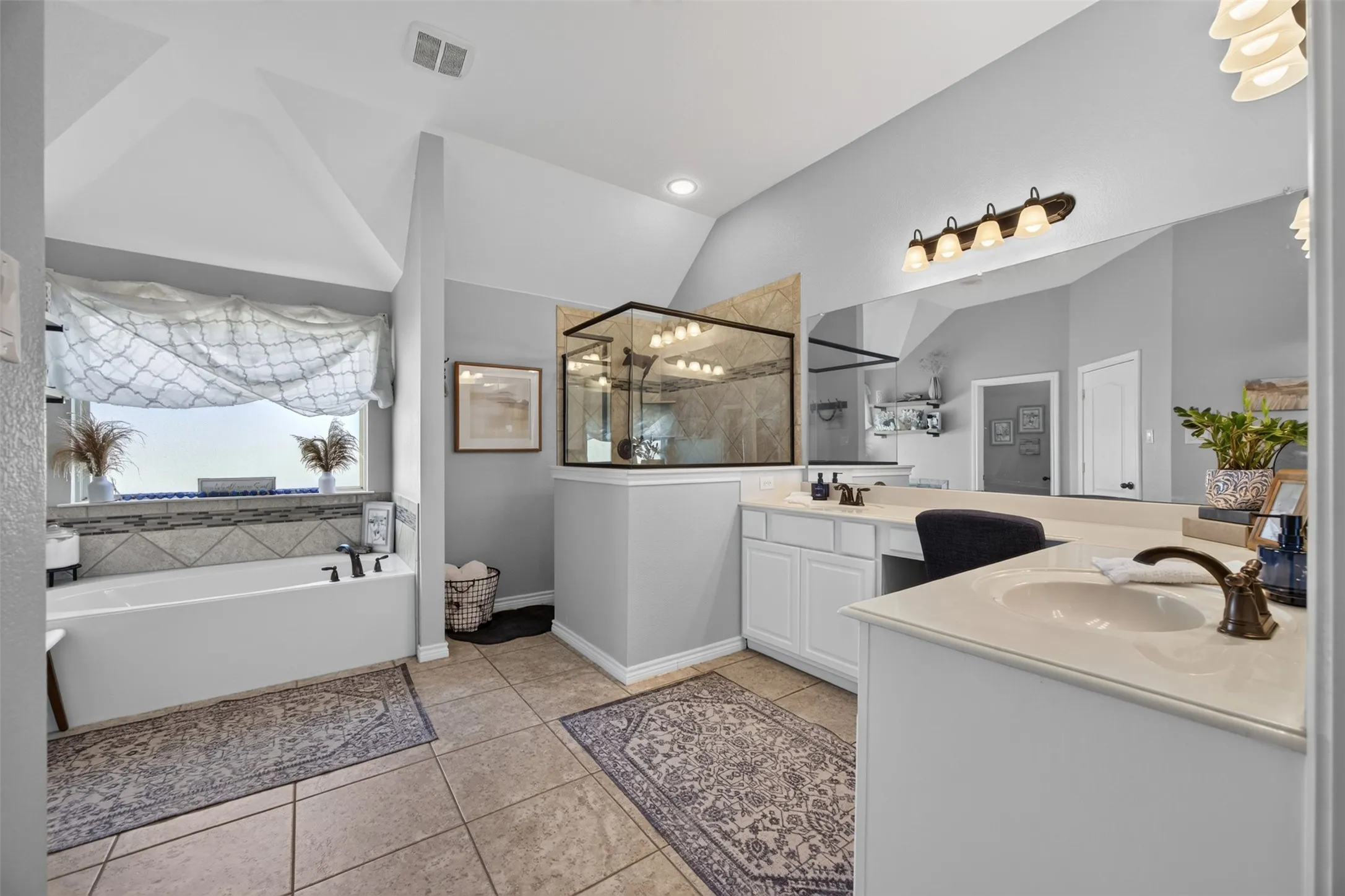Primary bath with garden tub, separate shower, and dual vanities