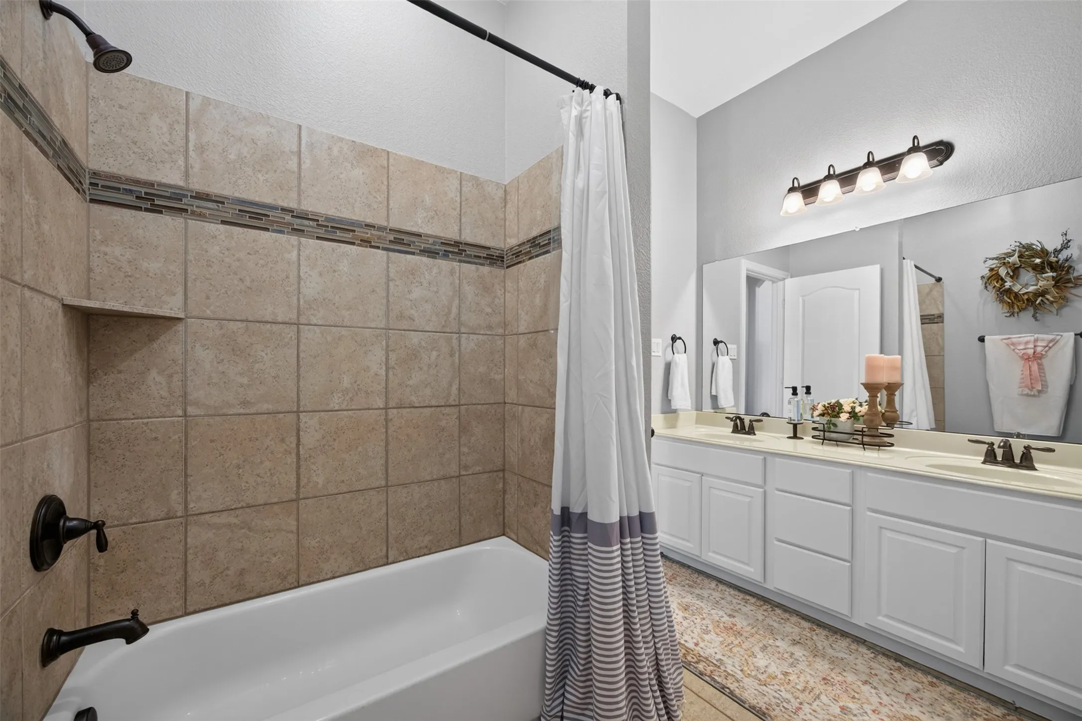 Full bathroom with dual sinks and tub