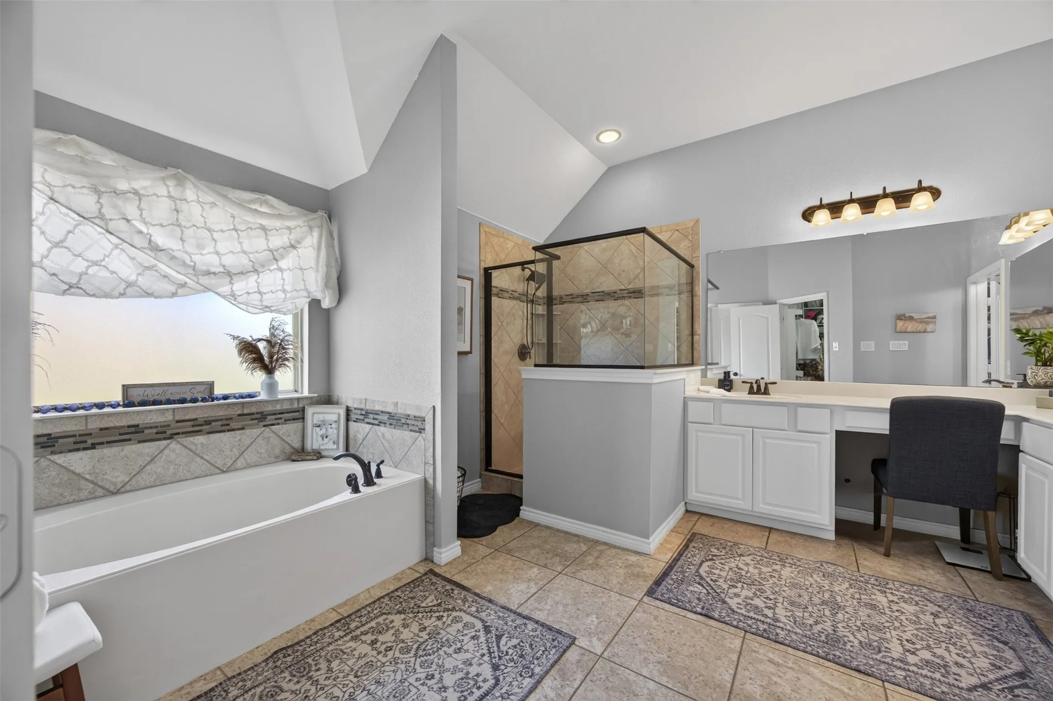 Primary bath with garden tub, separate shower, and dual vanities