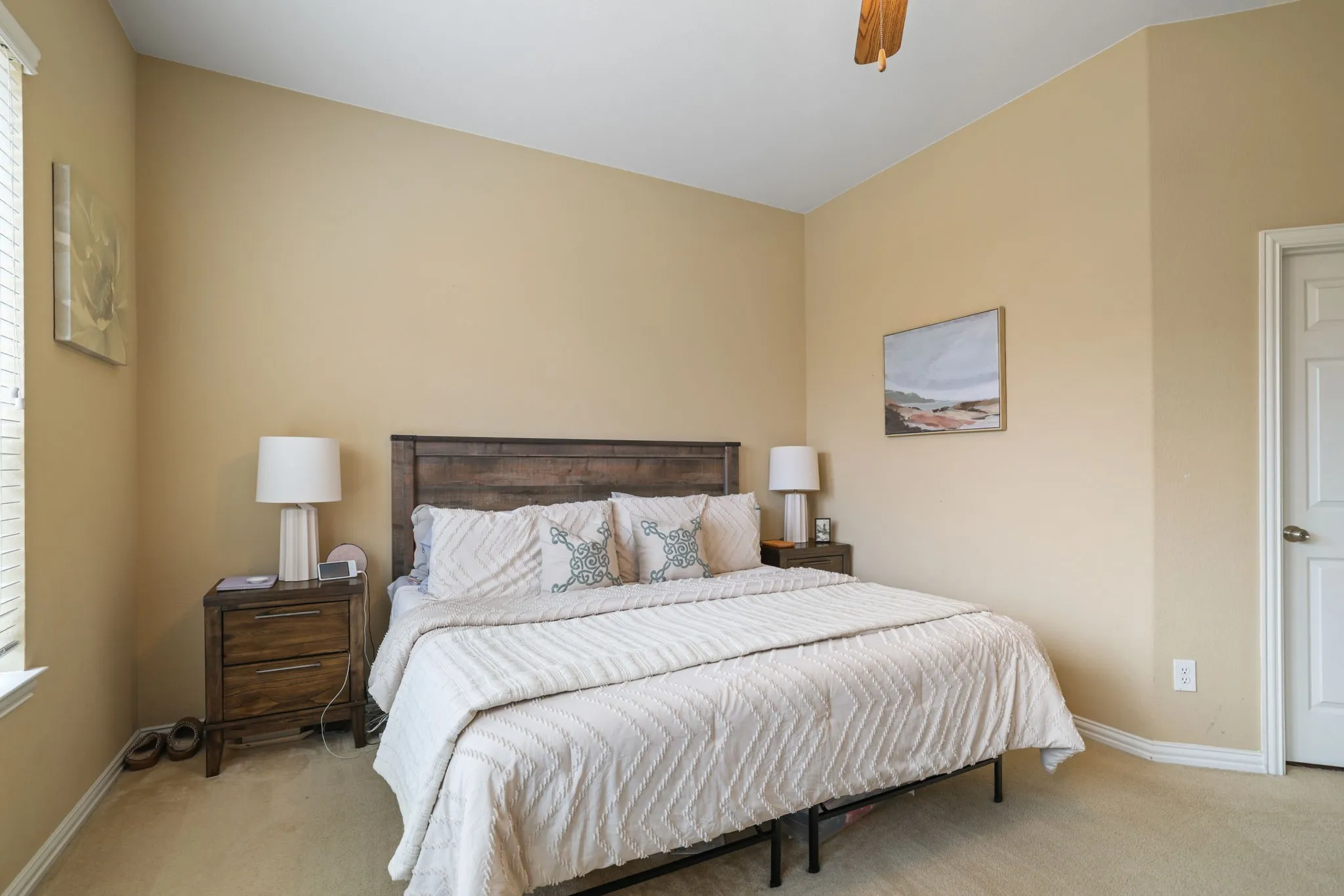 Room featuring neutral tone walls, carpet flooring, a ceiling fan, and a paneled door