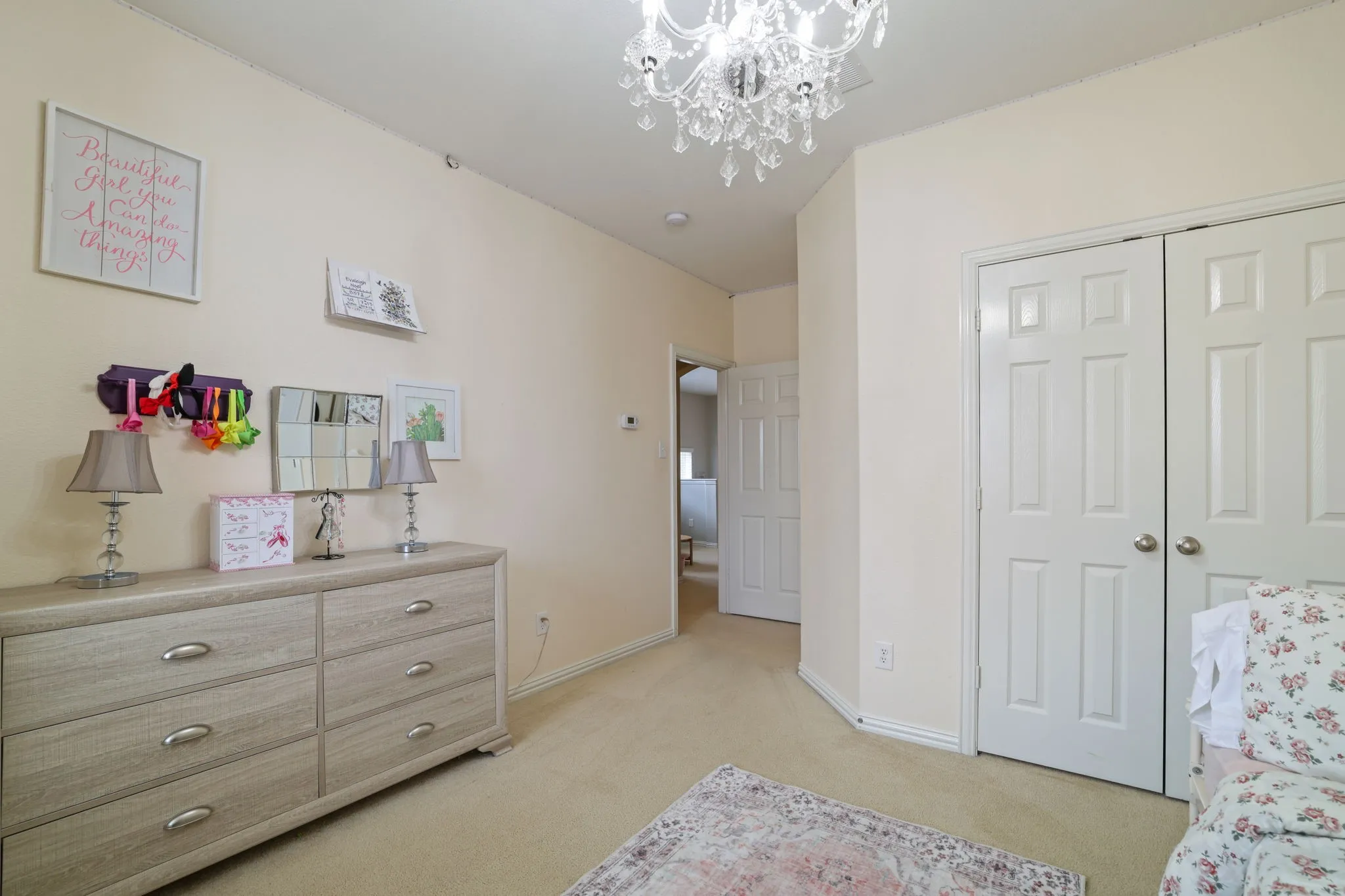 Recessed lighting, chandelier, neutral tone walls, bi-fold closet doors, and light-colored carpet