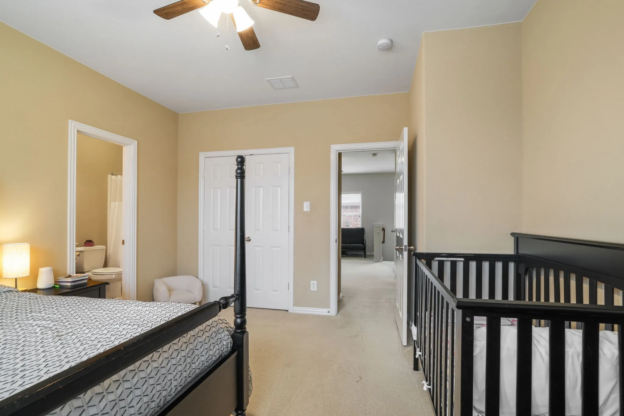 Neutral wall tones, ceiling fan with integrated lighting, dual bi-fold closet doors, and carpeted flooring